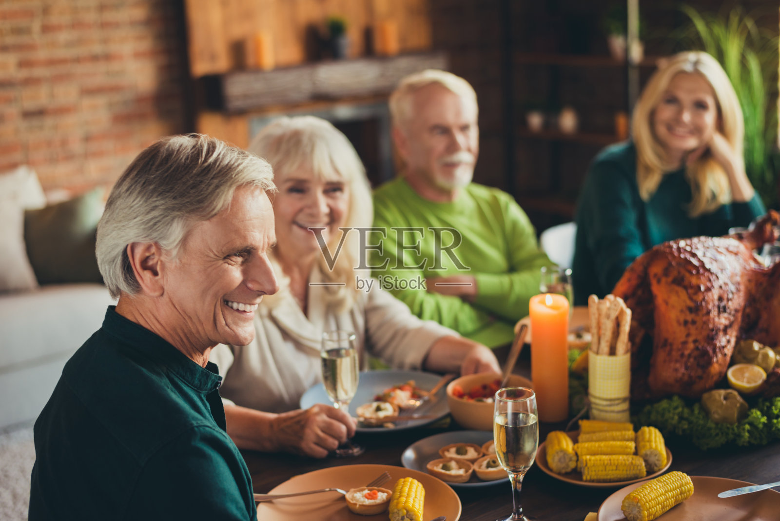 家庭团聚，老成员听庆祝祝酒，感谢，喝起泡酒在客厅室内照片摄影图片