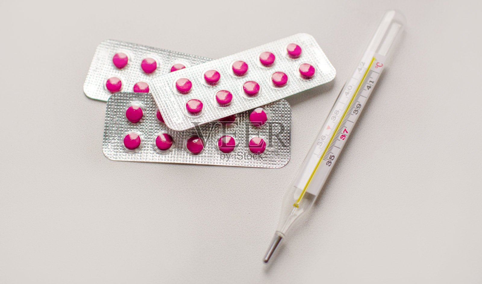 彩色药丸和医疗体温计在白色背景近处照片摄影图片