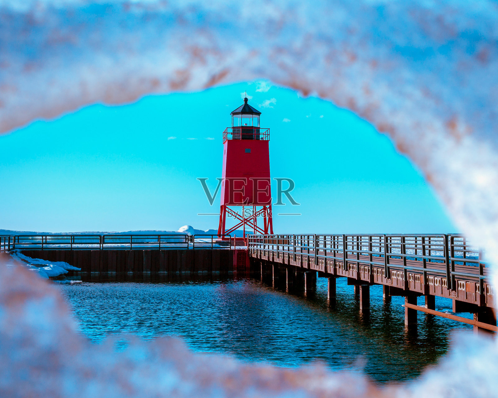 在密歇根州的Charlevoix，透过冰原拍摄的一座红色灯塔照片摄影图片