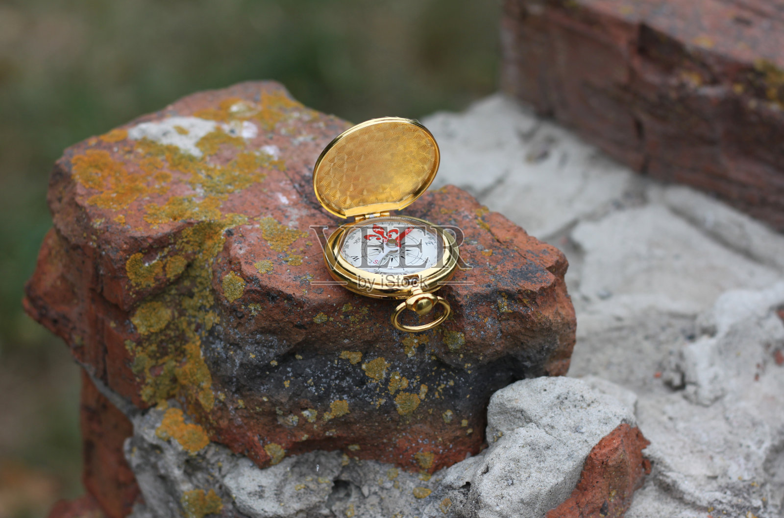 铁制指南针贴在砖墙上，象征旅游用指南针照片摄影图片