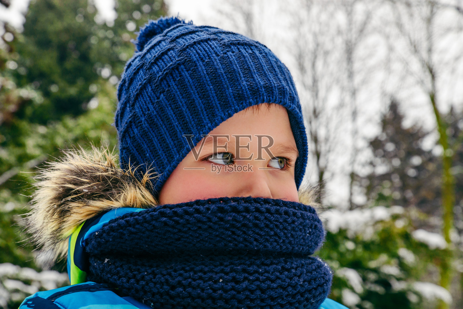 可爱的小蹒跚学步的男孩肖像在帽子和围巾照片摄影图片