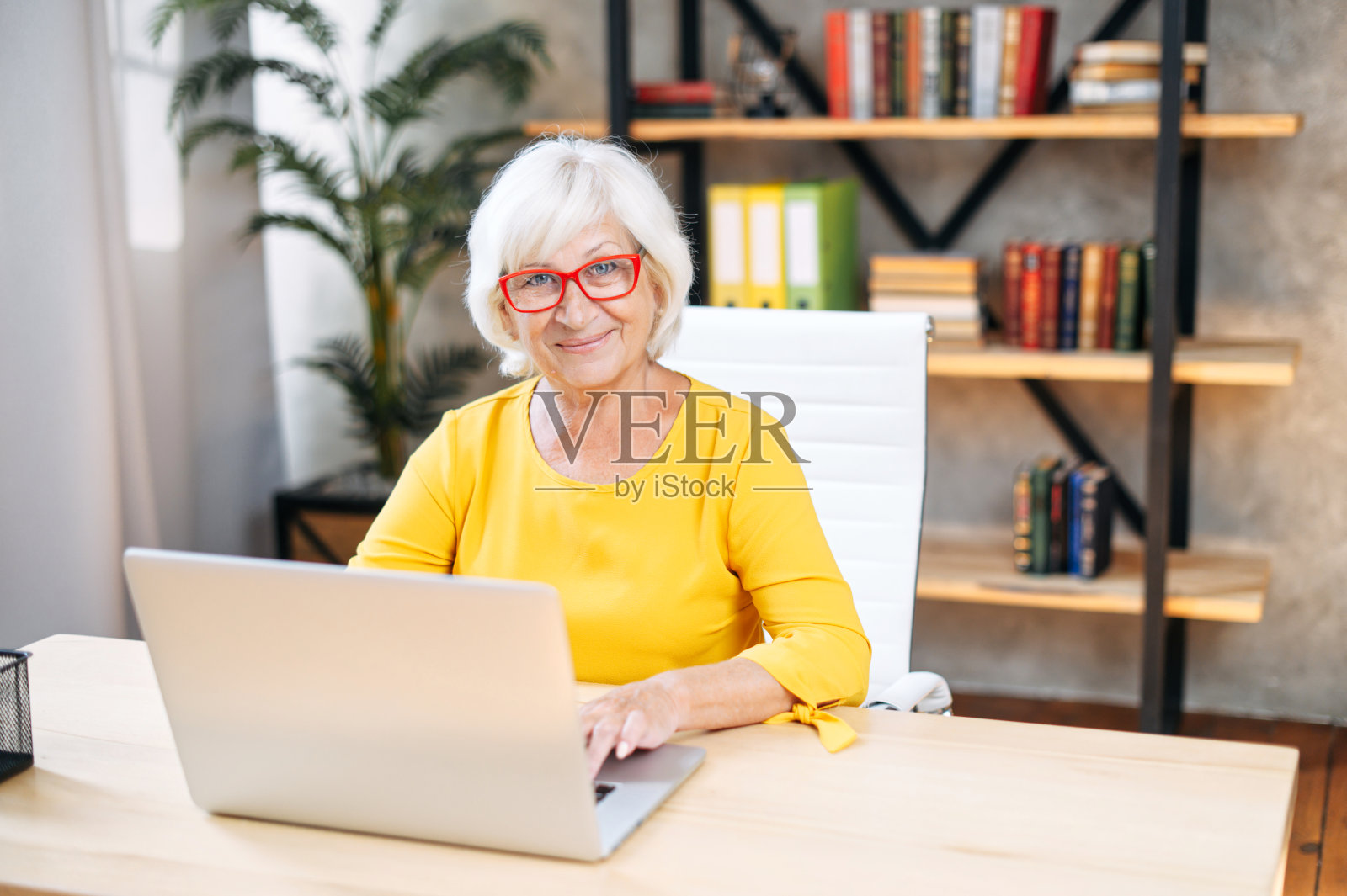 一位高级女士在室内使用笔记本电脑工作照片摄影图片