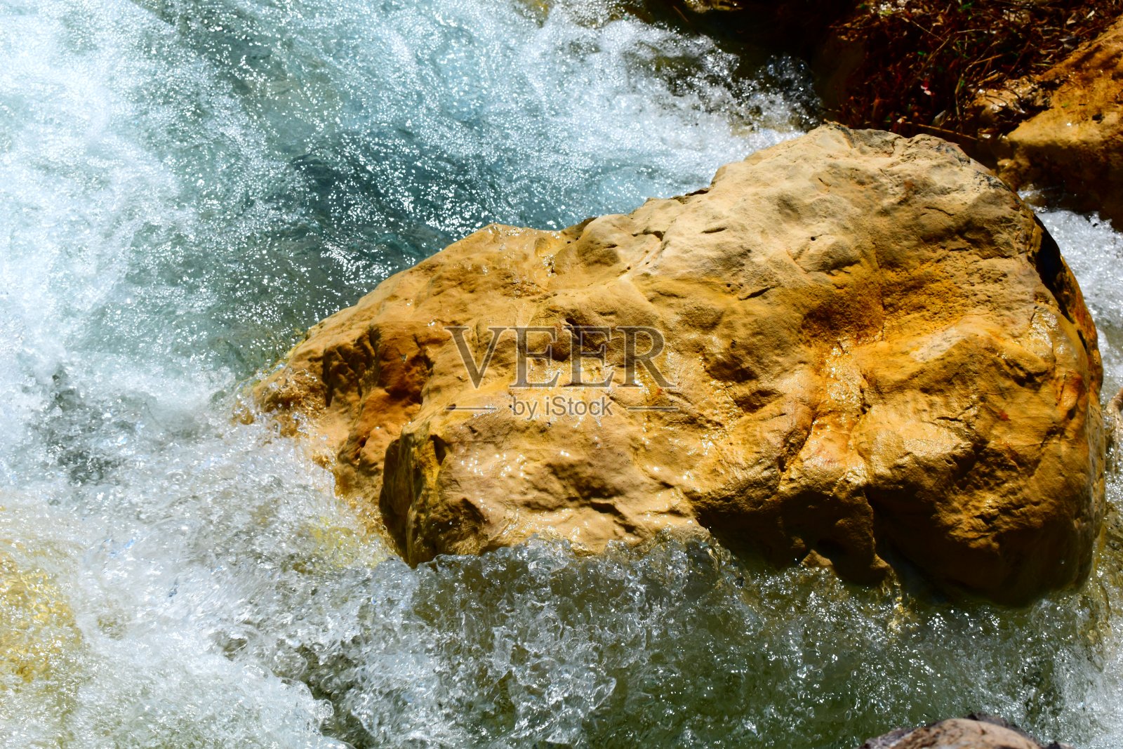 被溅起水花的棕色石头。照片摄影图片