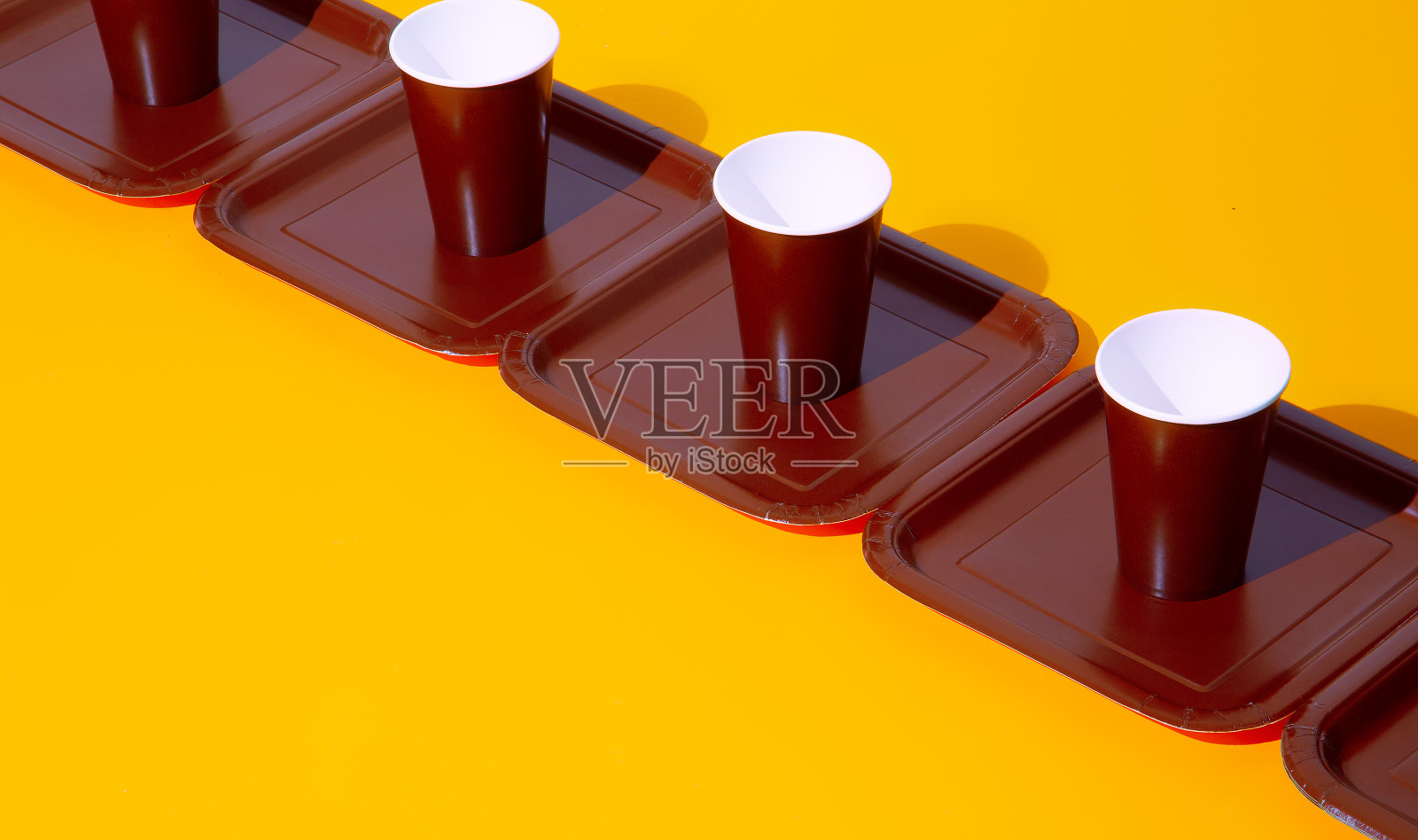 塑料盘子和杯子在黄色背景等距。最小的。静物画艺术。塑料自由概念照片摄影图片