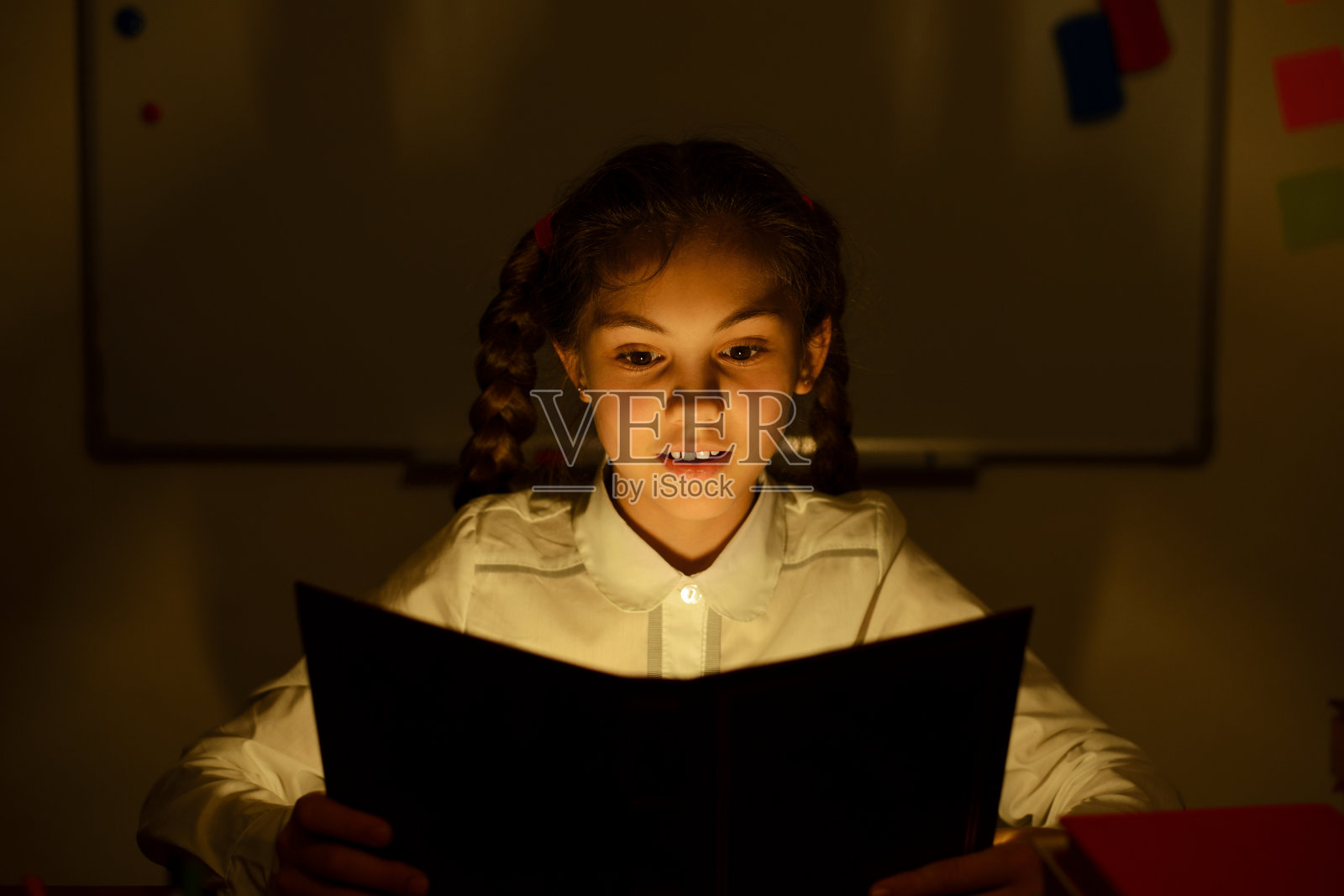 感兴趣和兴奋的女学生阅读一个有趣的故事，梦想和想象的事件照片摄影图片