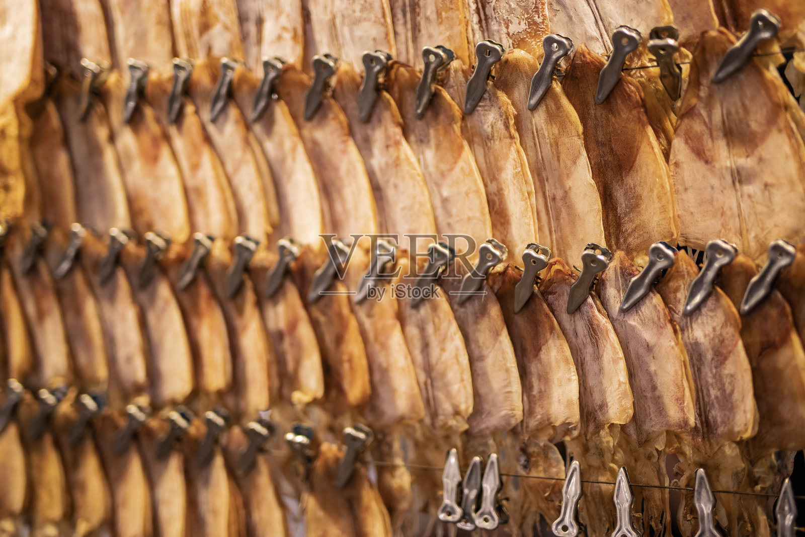 几条干鱿鱼在横杆上晒干。照片摄影图片