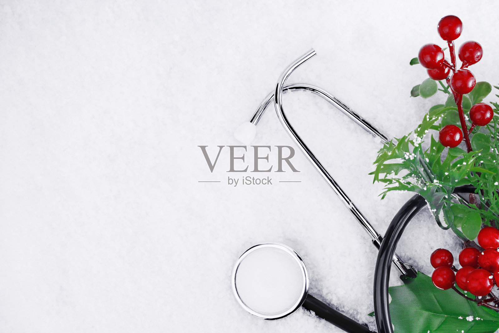 医用听诊器在圣诞节树枝附近的积雪背景上。圣诞节或新年的医学概念。断然。本空间照片摄影图片