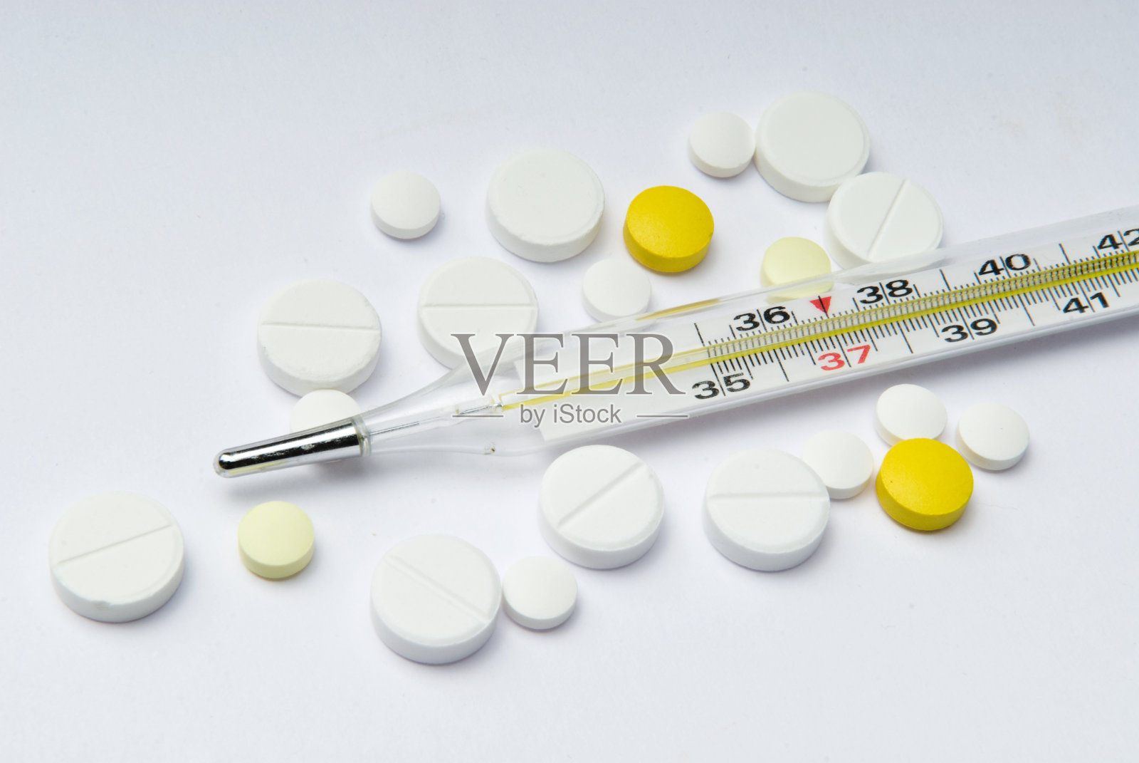体温计和多色药丸，白底照片摄影图片