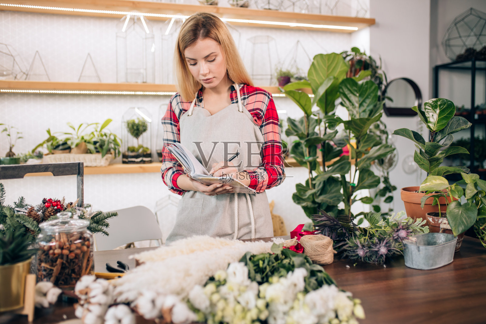 年轻的花店女士拿着笔记本照片摄影图片