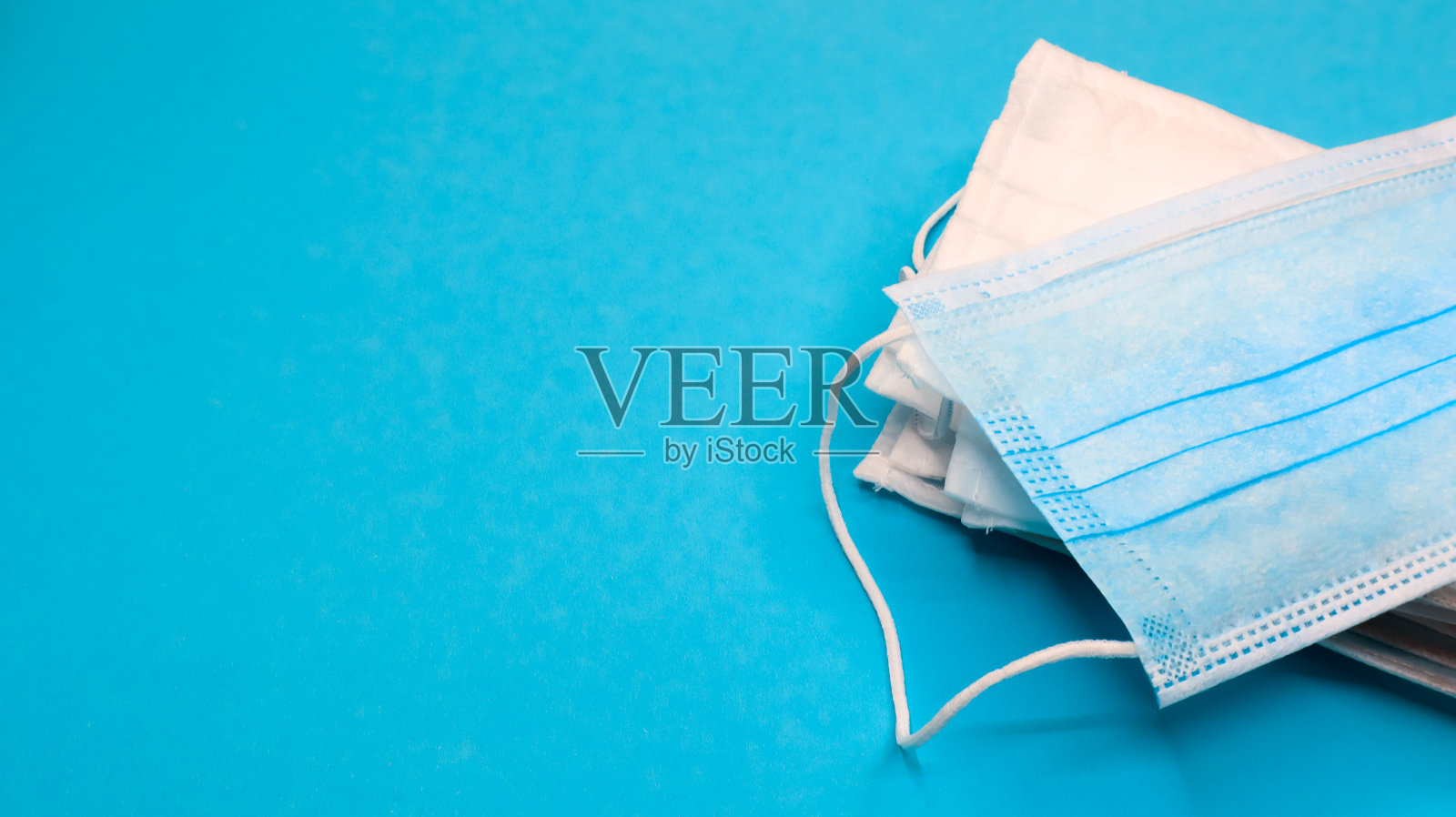 冠状病毒保护。带耳圈的抗病毒防护医用口罩。口罩的背景。呼吸综合征、冠状病毒病。许多折叠医用口罩照片摄影图片