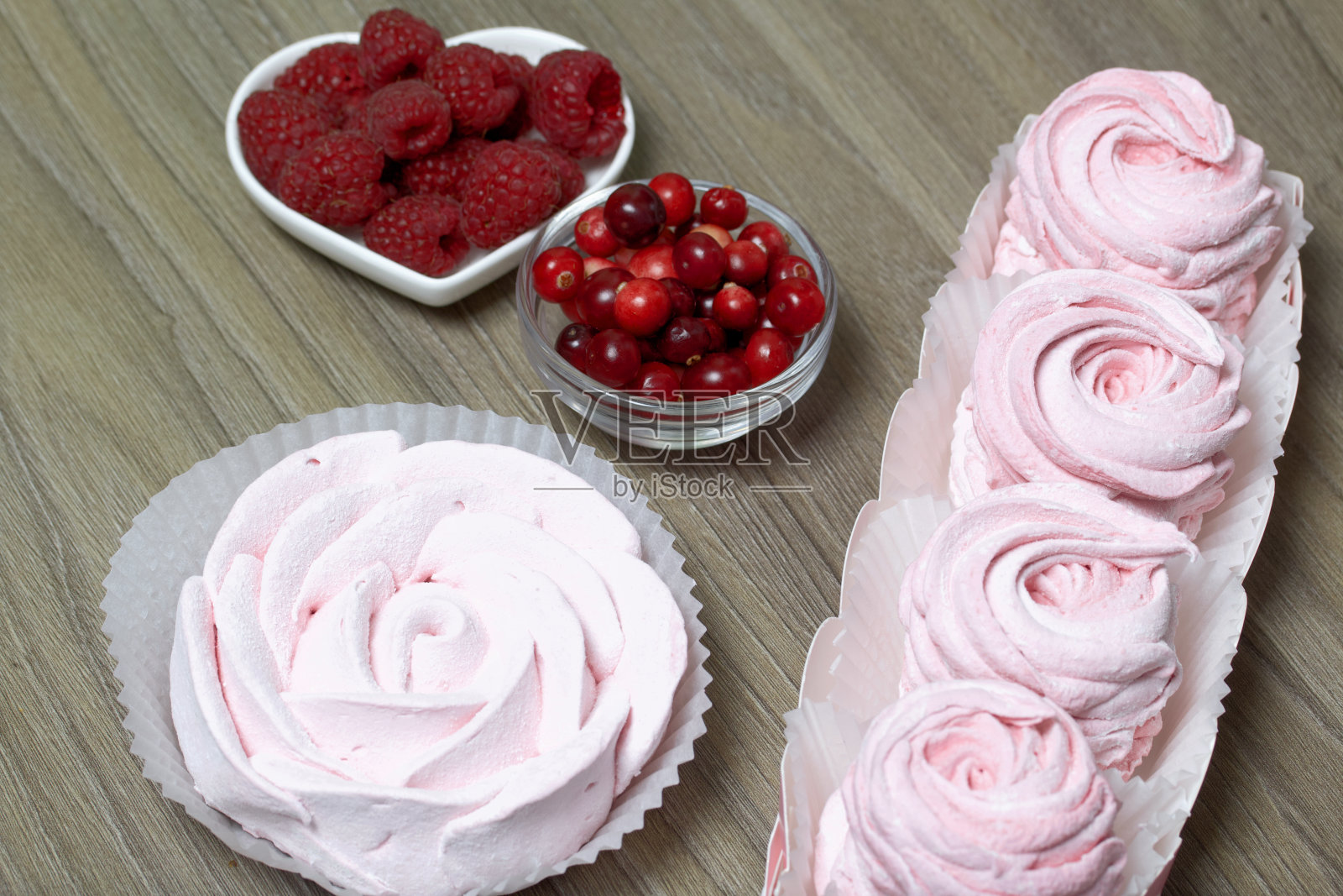 礼品盒里的粉色棉花糖。附近有一束蔓越莓和覆盆子。照片摄影图片