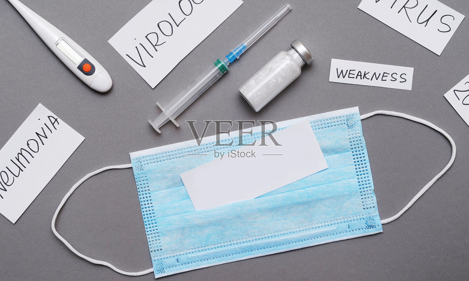 冠状病毒的概念。防护口罩和刻有冠状病毒症状字样的纸。照片摄影图片