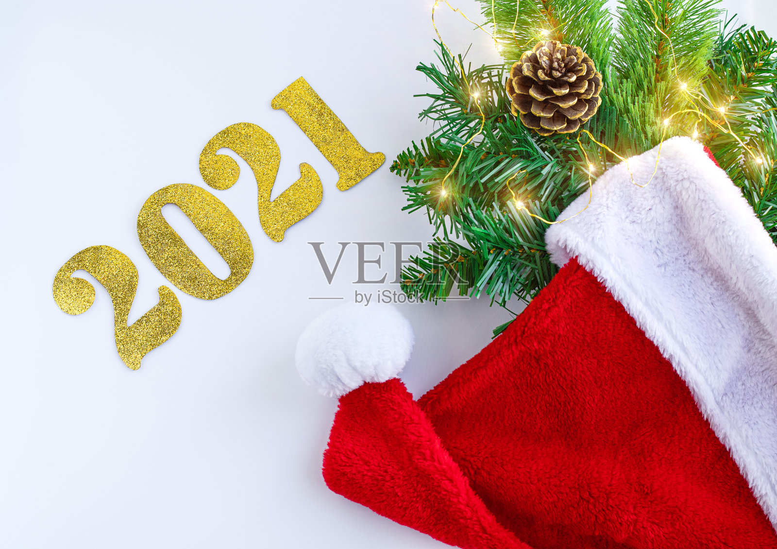 圣诞快乐，新年快乐。圣诞帽，云杉树枝，锥形，礼盒和白色背景照明。圣诞贺卡照片摄影图片