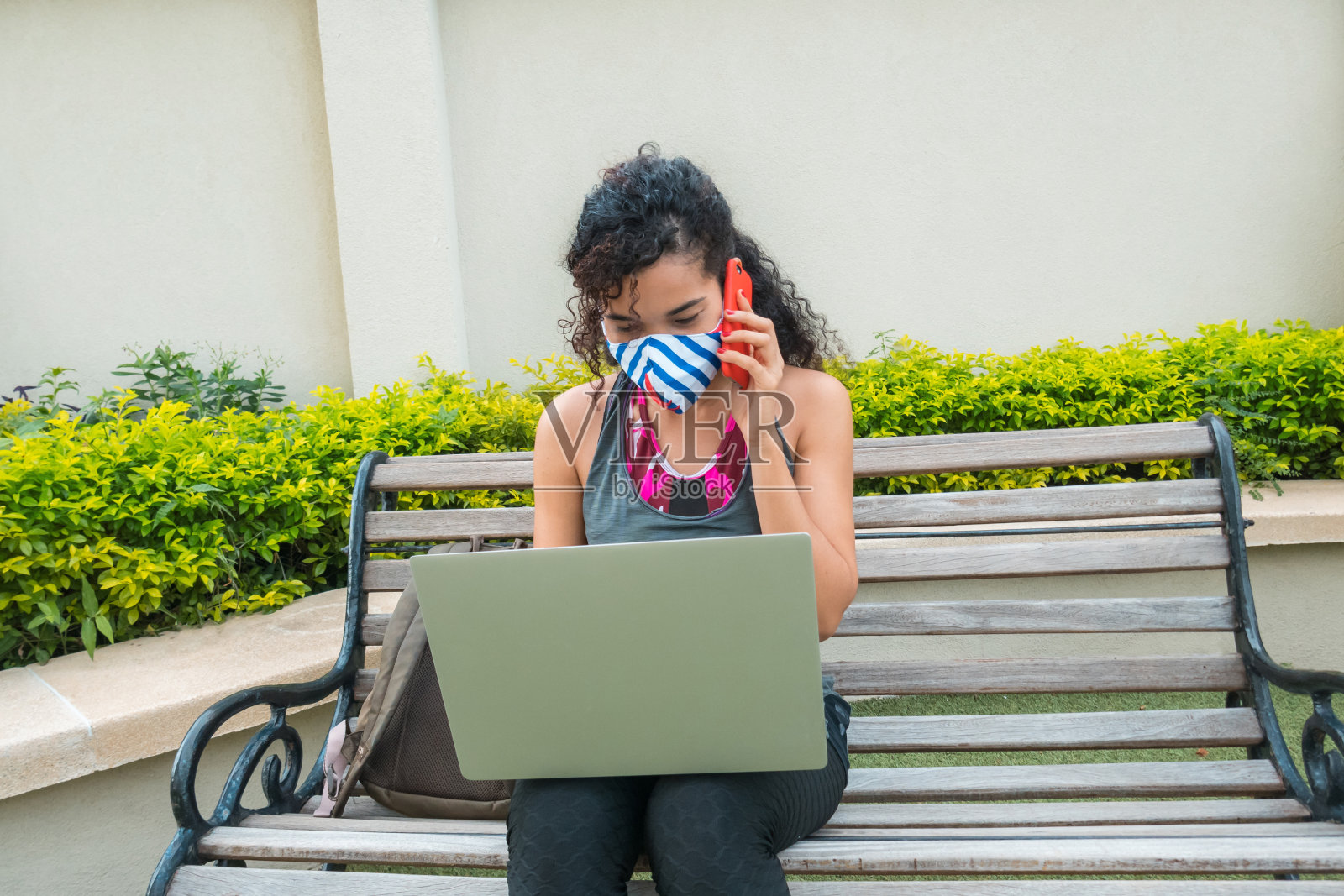 社交距离:白天在户外公园打工的女性。为了预防Covid-19病毒，她戴着口罩。照片摄影图片