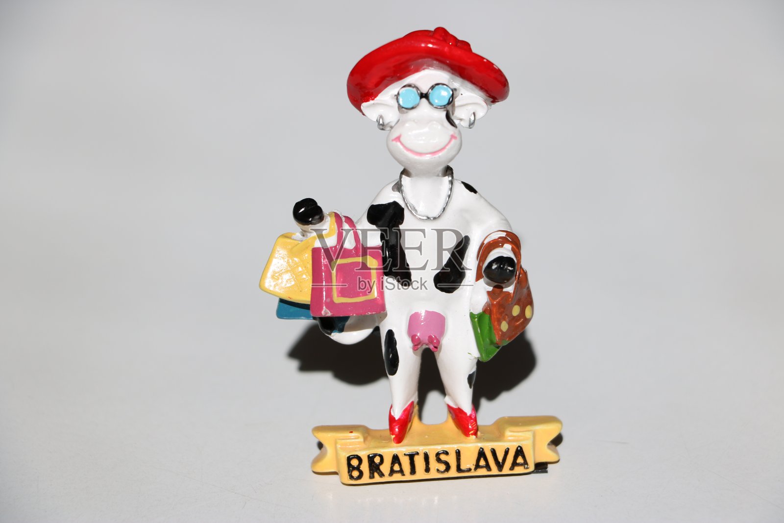 白色陶瓷支架牛与各种购买，红帽子和眼镜和布拉迪斯拉发的名字在底部。照片摄影图片