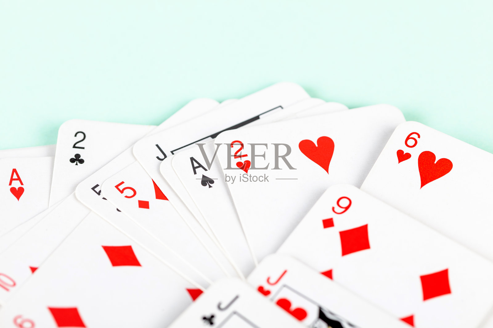 一大堆小小的分散的扑克牌，宏观的，特写的，桥牌。堆小卡片面对抽象的蓝色背景纹理。纸牌游戏、赌博、魔术和休闲概念照片摄影图片