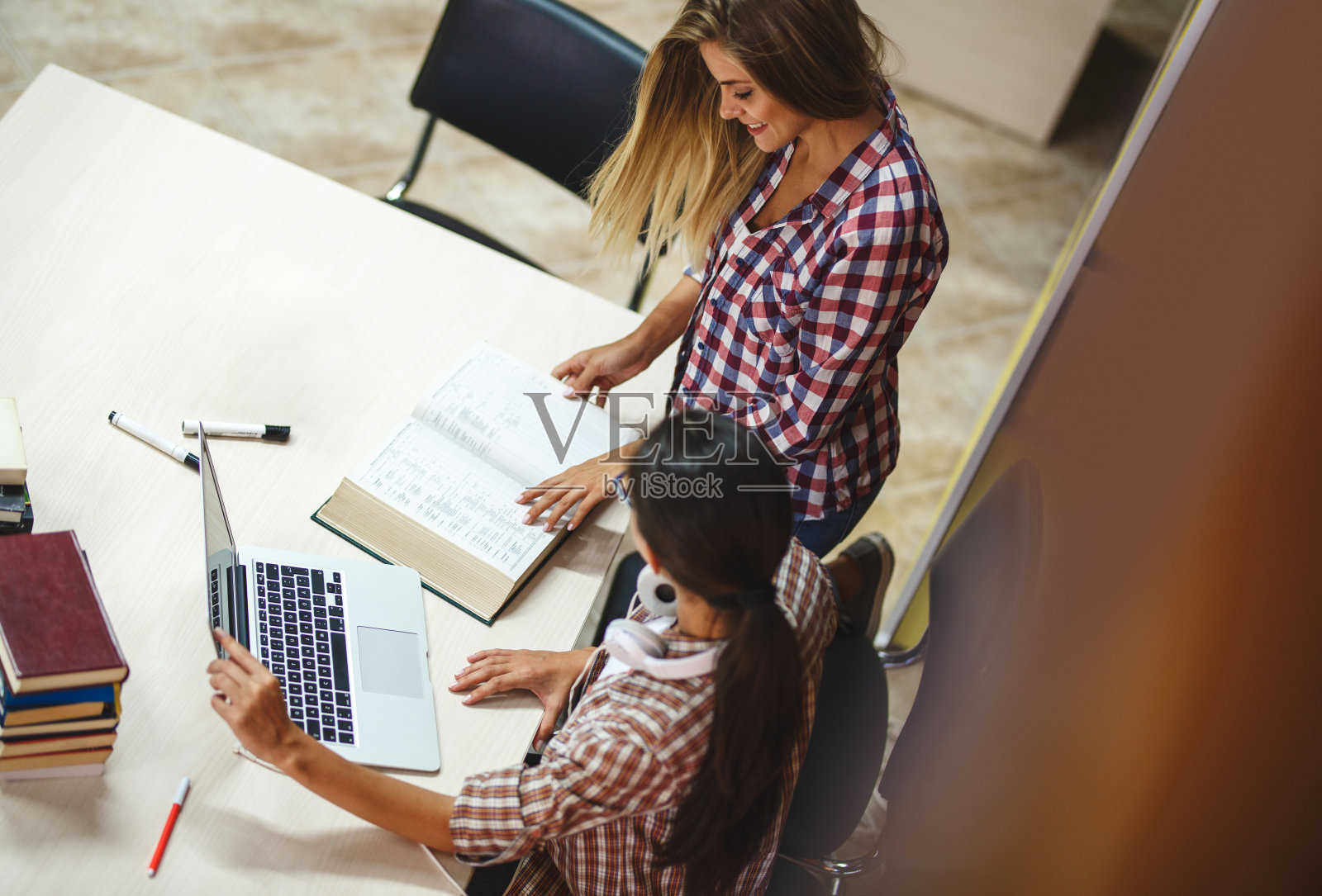 一群女学生上午在大学图书馆学习。照片摄影图片