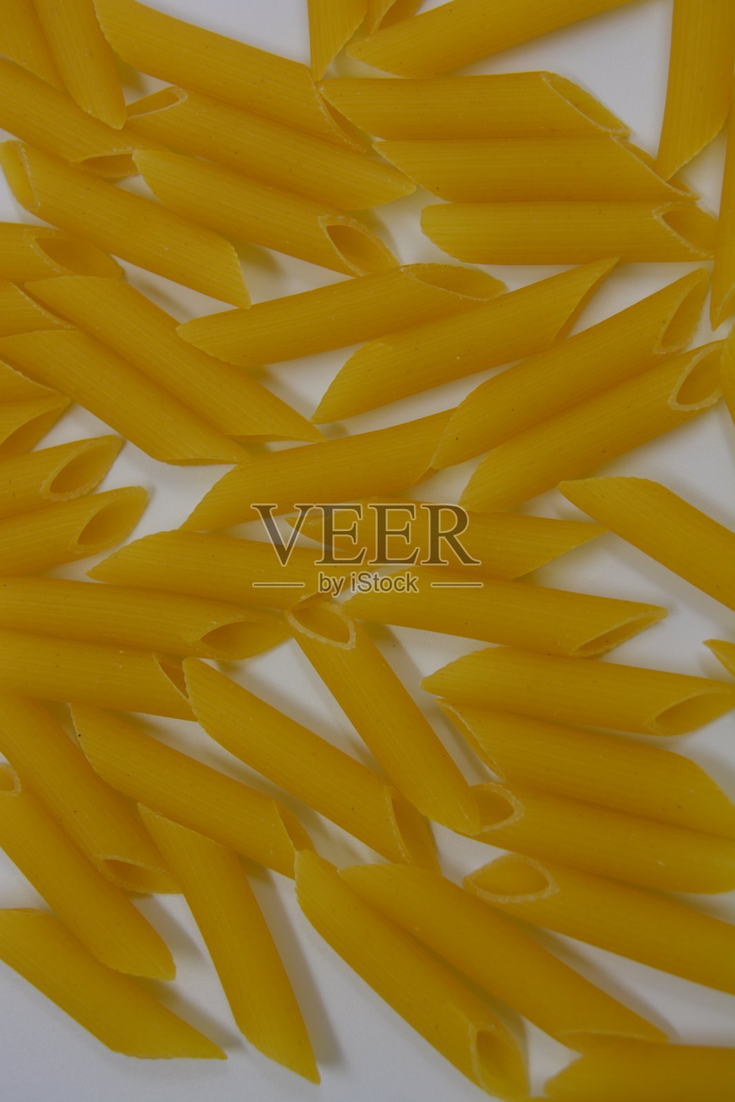 意大利黄面食、面条面食，硬质小麦羽毛散落在白色的背景上。照片摄影图片