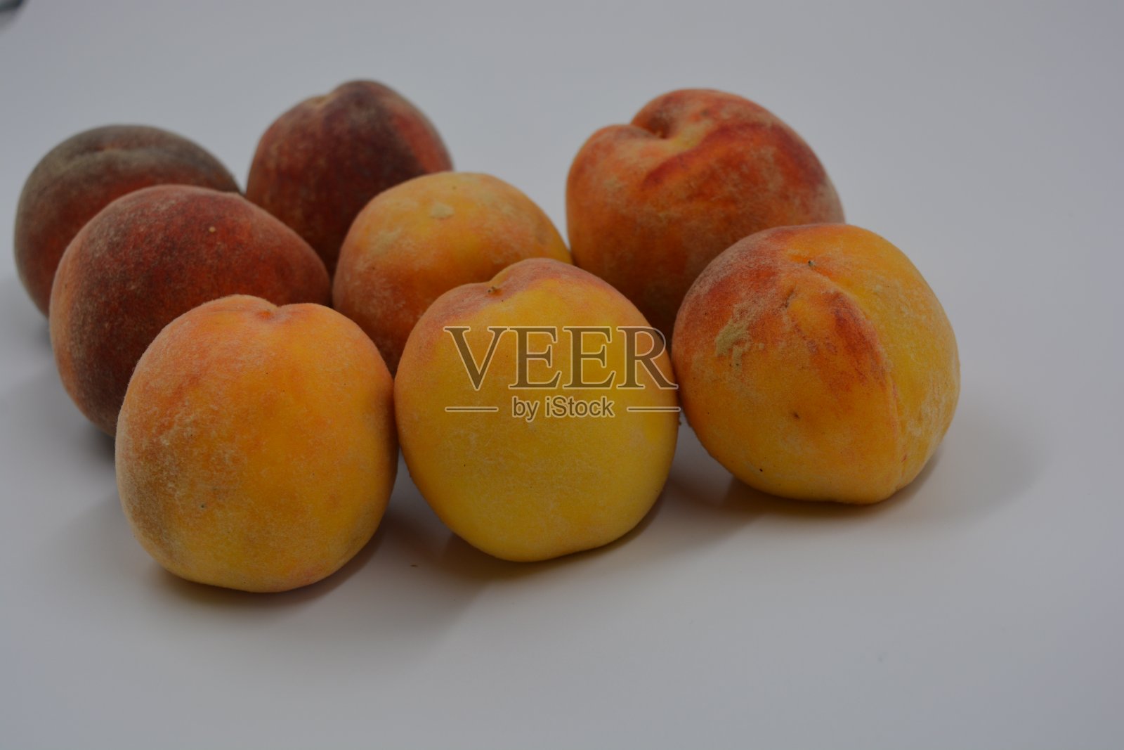 美味的、成熟的、多汁的红黄桃位于白色的背景上。照片摄影图片