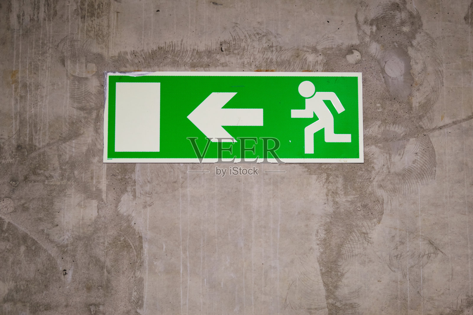 发电厂墙上的绿色紧急消防出口标志。照片摄影图片