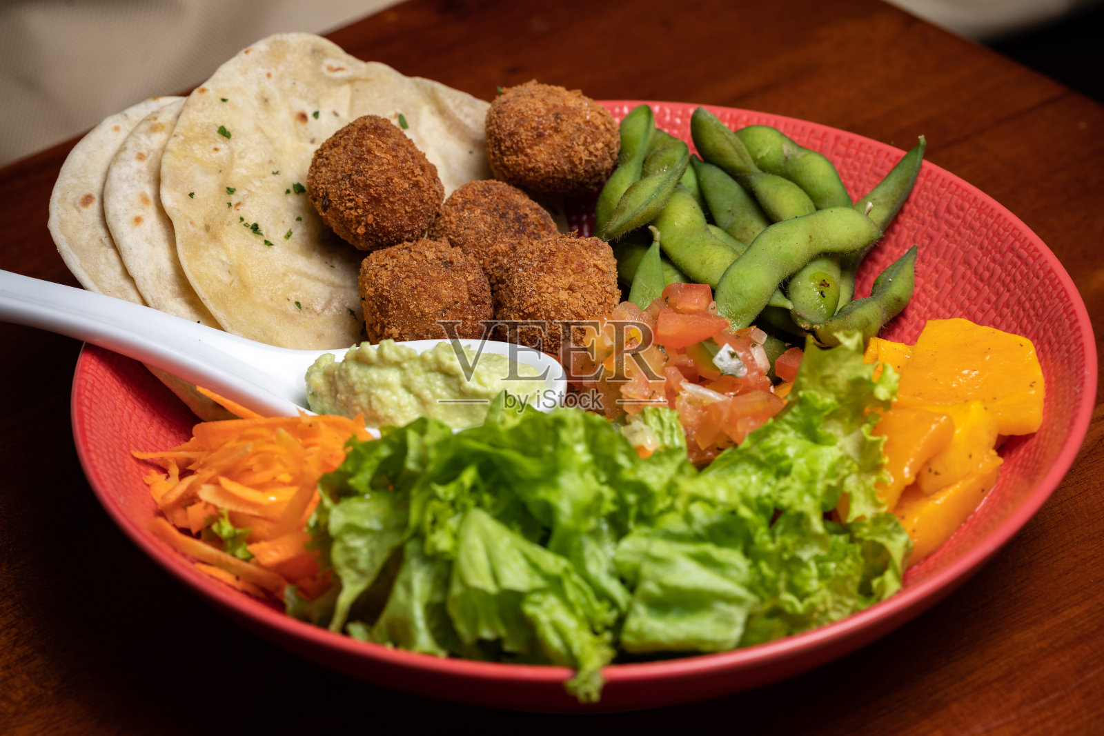 纯素炸豆丸子配蔬菜和希腊酸奶酱，阿拉伯美食，佛陀碗皮塔饼照片摄影图片