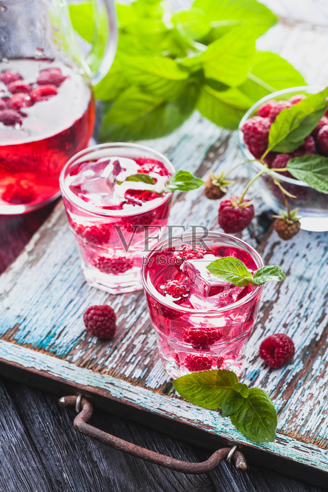 旧木桌上的红覆盆子鸡尾酒配冰和新鲜薄荷照片摄影图片