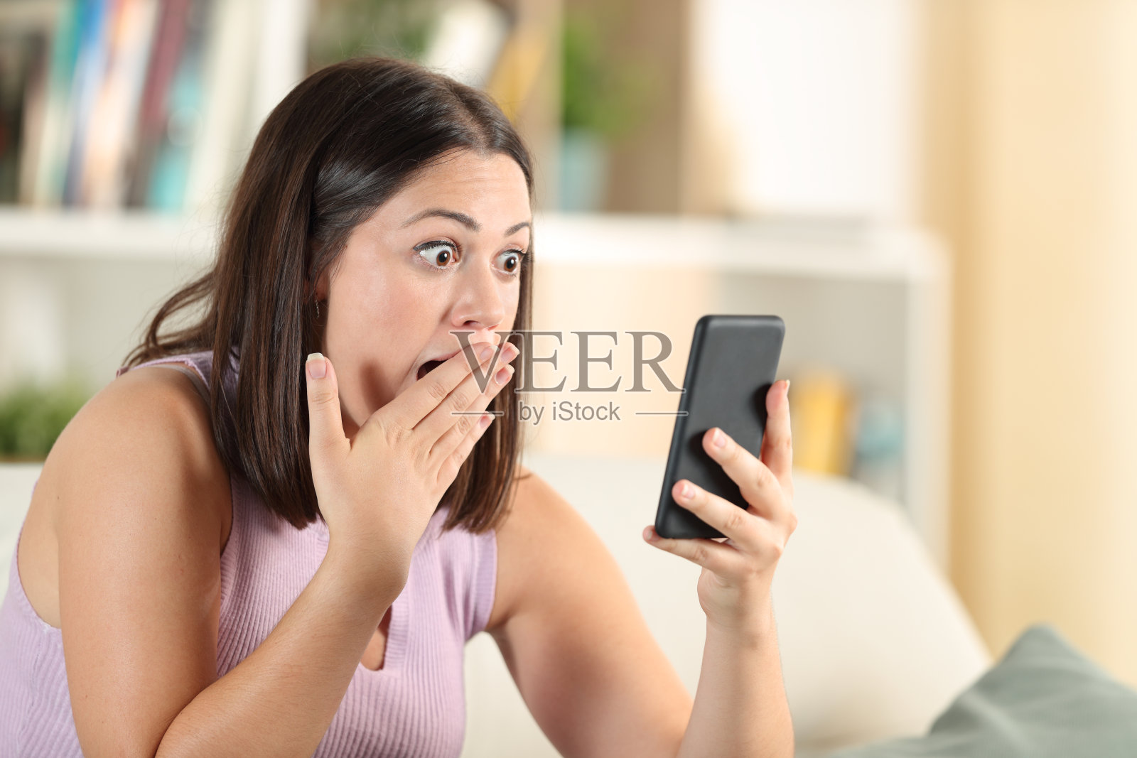 惊讶的女人检查手机发现惊人的内容照片摄影图片