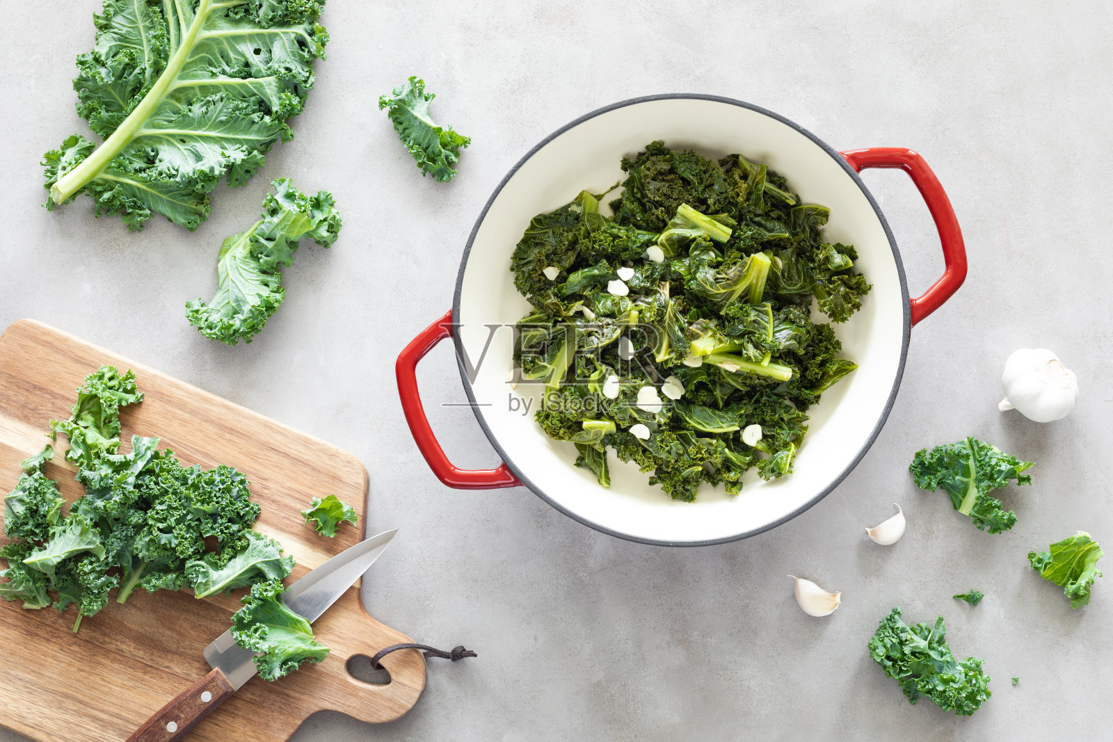 铁锅蒜头炒羽衣甘蓝在厨房桌上，健康的食物概念，超级食物照片摄影图片