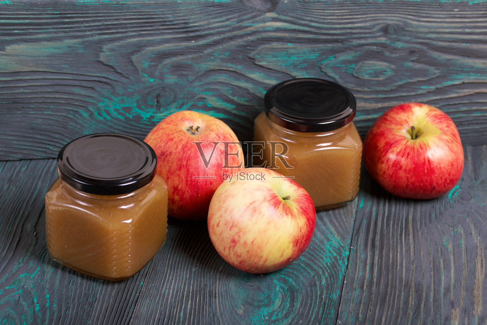 罐装苹果酱。附近是成熟的苹果。在拉丝板上，涂成黑色和白色。照片摄影图片