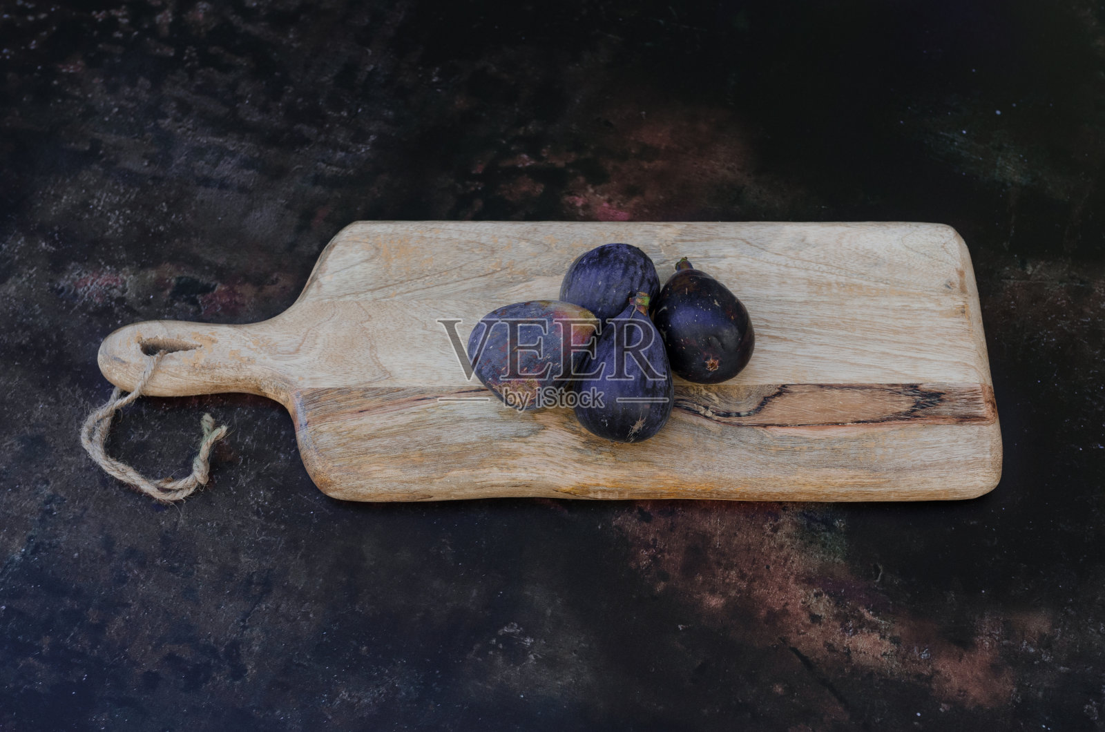 一块木板上放着四个有机无花果。照片摄影图片