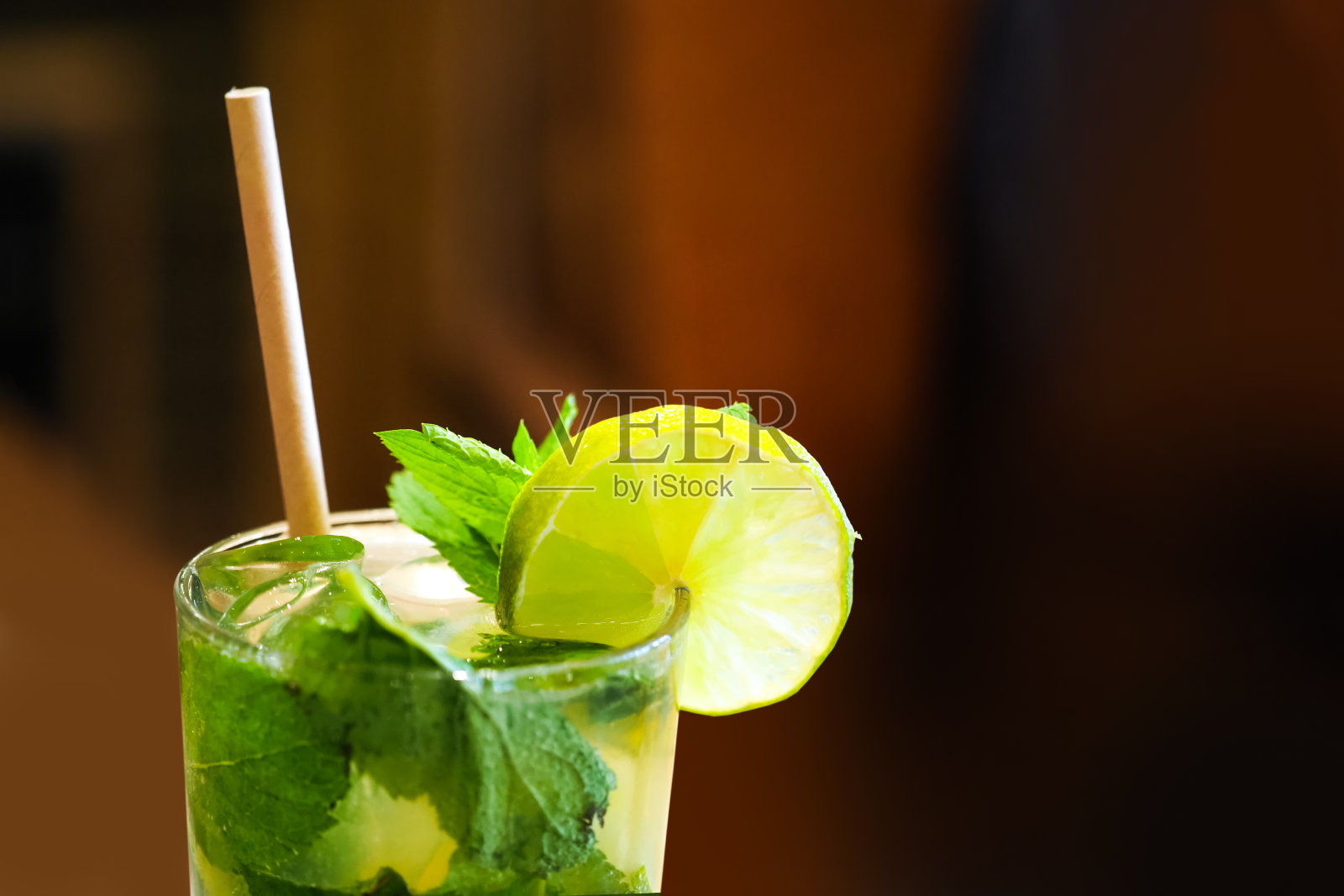 用玻璃杯自制柠檬水。由薄荷叶、青柠片、柠檬、果汁、冰块制成的提神冷饮。莫吉托照片摄影图片