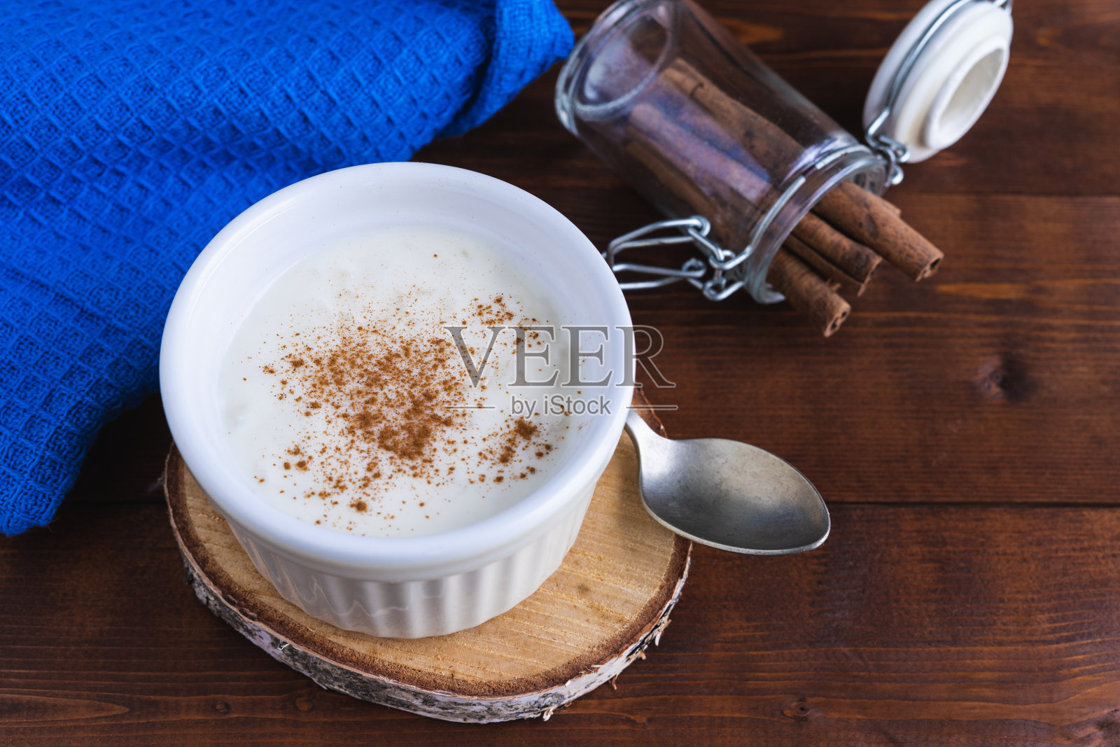 奶油米布丁和肉桂木底座。糕点的概念。照片摄影图片