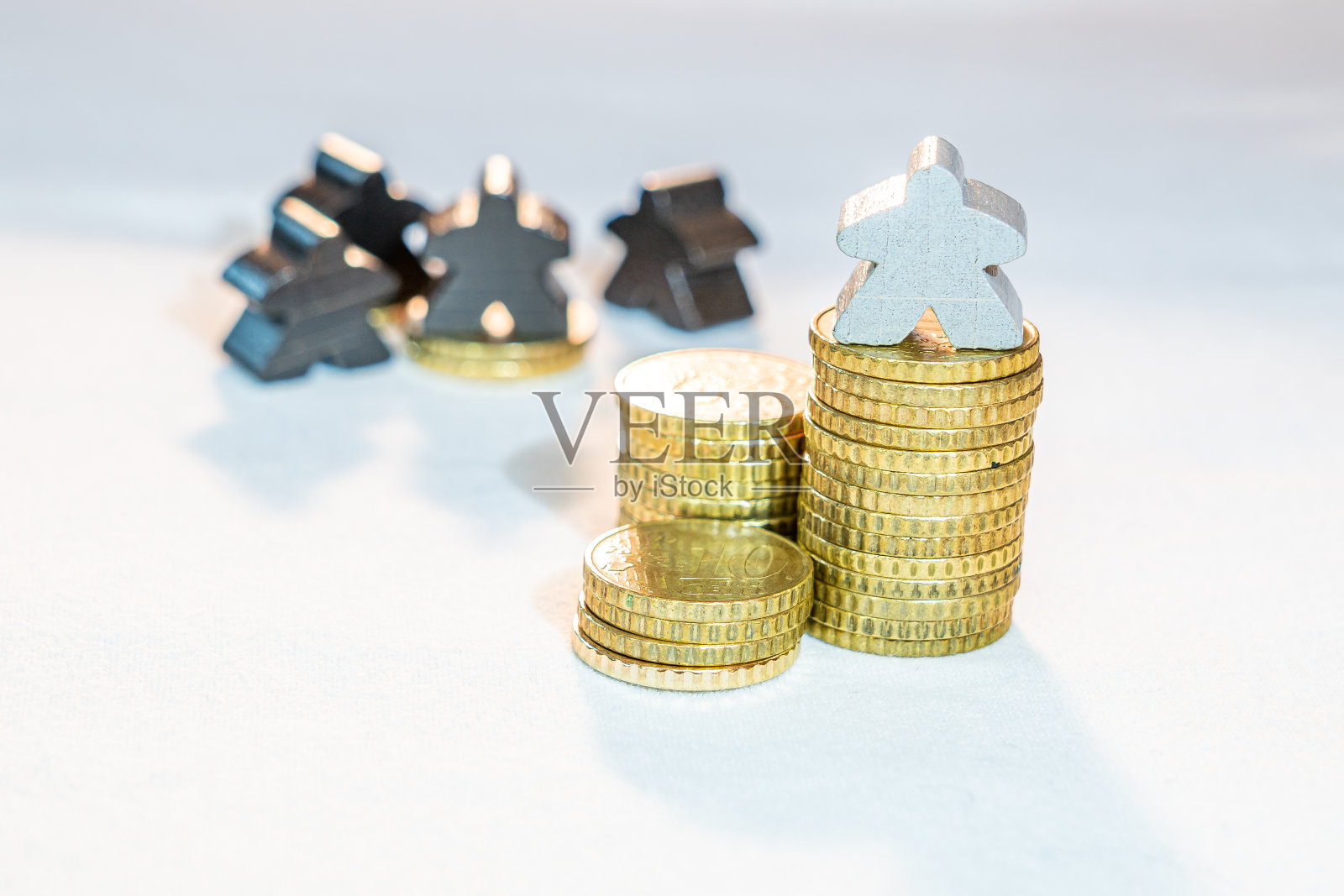 资产的不平等分配显示在一堆欧元分硬币上的木meeples照片摄影图片