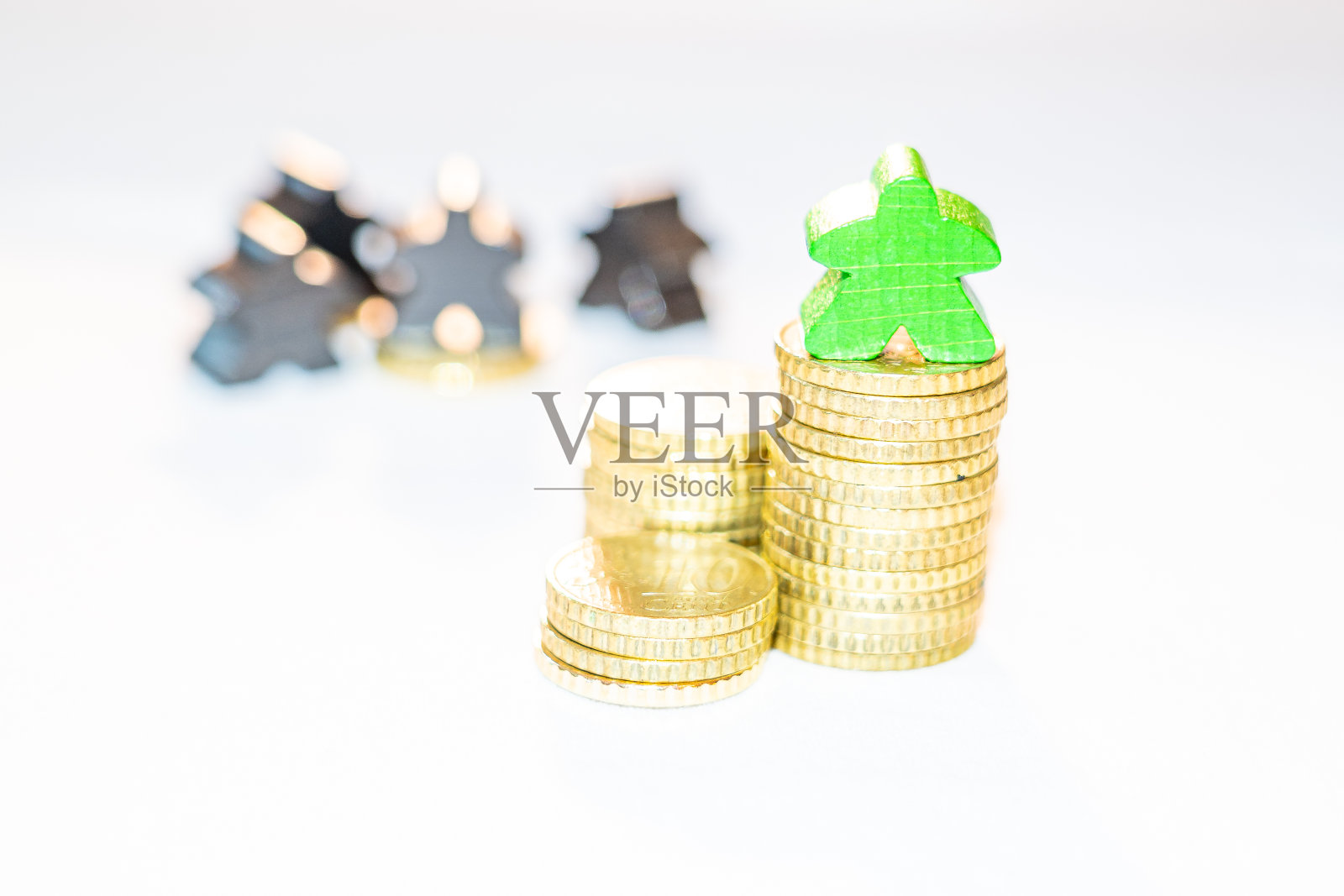 资产的不平等分配显示在一堆欧元分硬币上的木meeples照片摄影图片