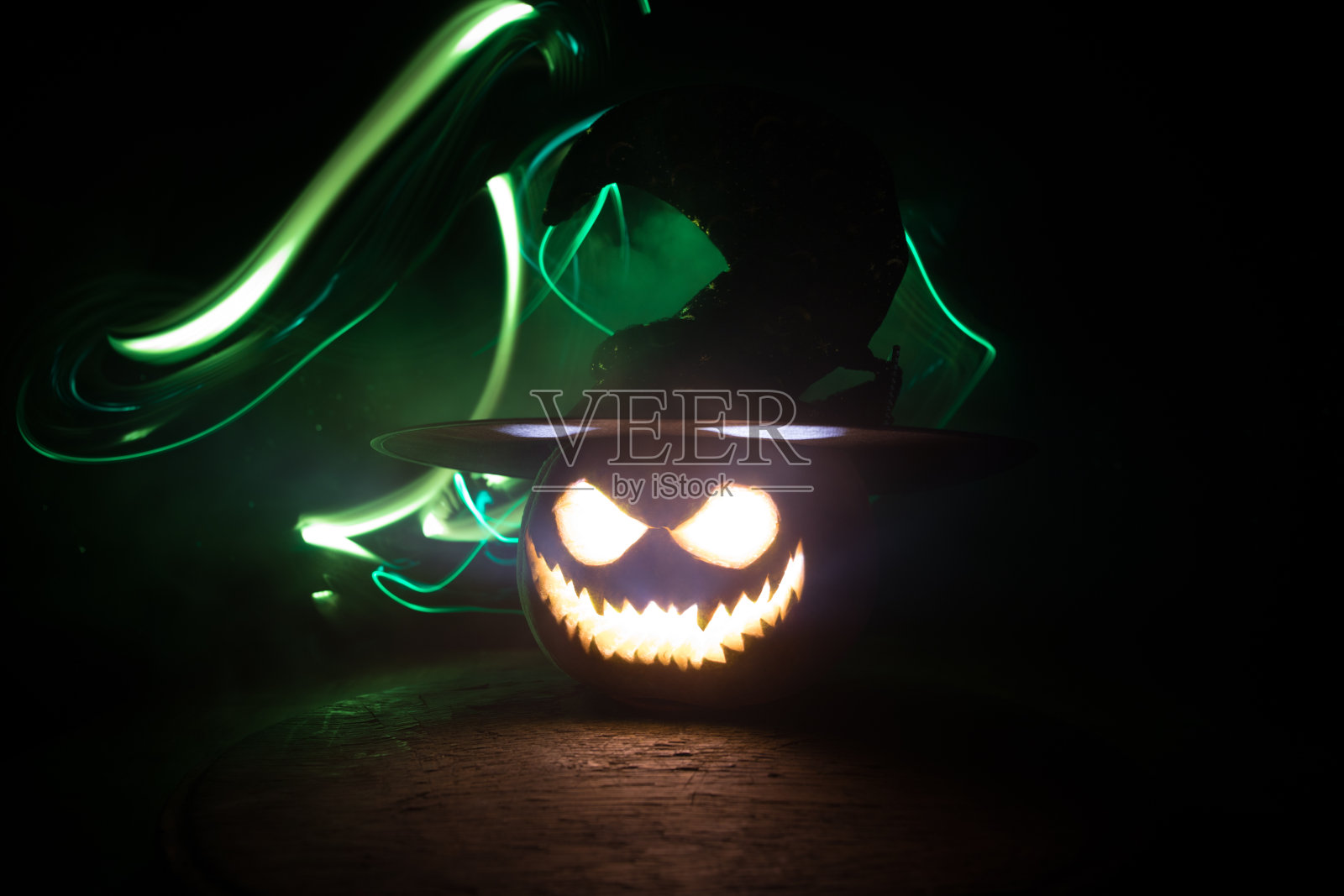 万圣节南瓜微笑和恐怖的眼睛派对之夜。近距离观看可怕的万圣节南瓜与眼睛发光内部在黑色的背景照片摄影图片