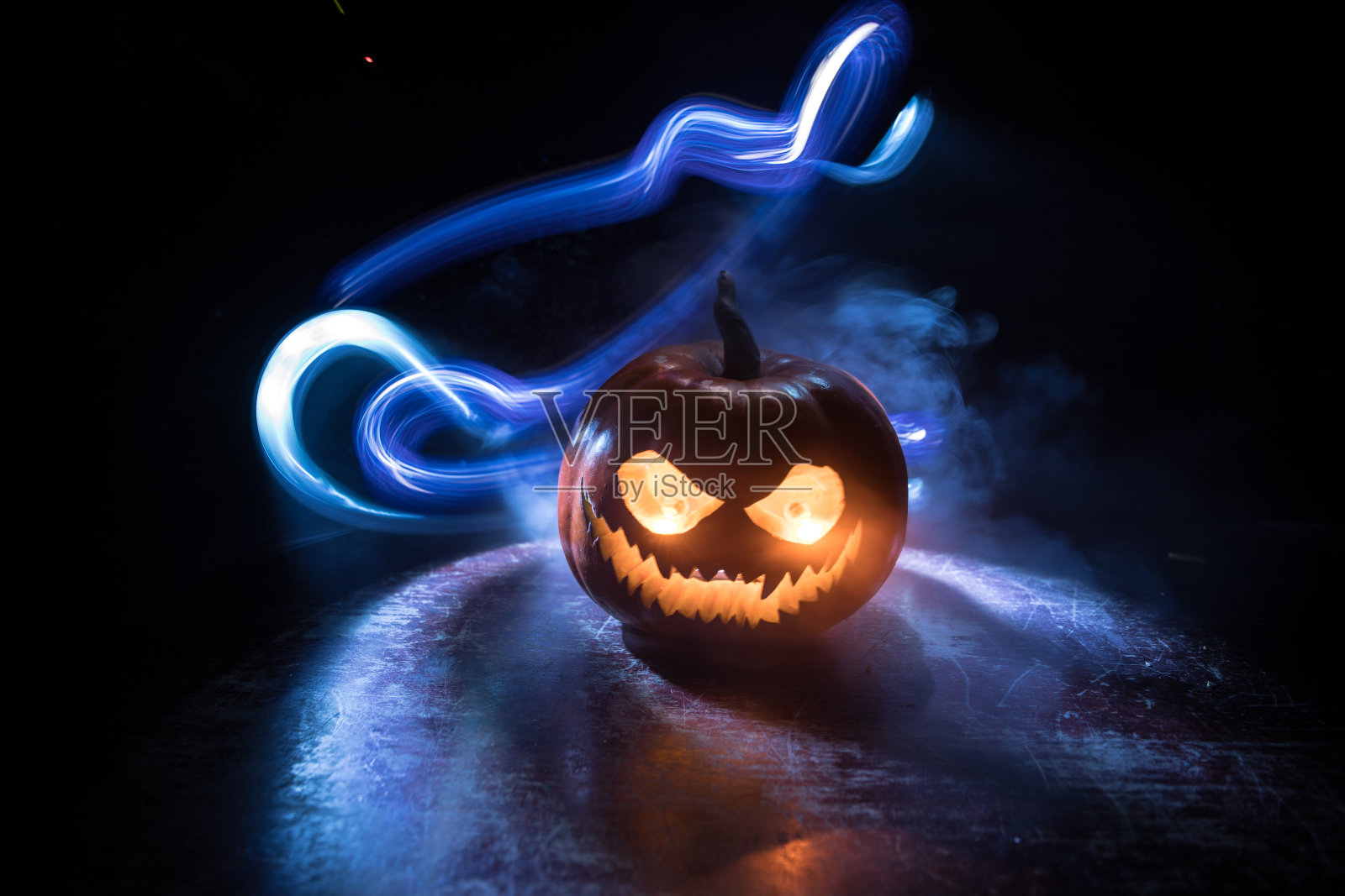 万圣节南瓜微笑和恐怖的眼睛派对之夜。近距离观看可怕的万圣节南瓜与眼睛发光内部在黑色的背景照片摄影图片