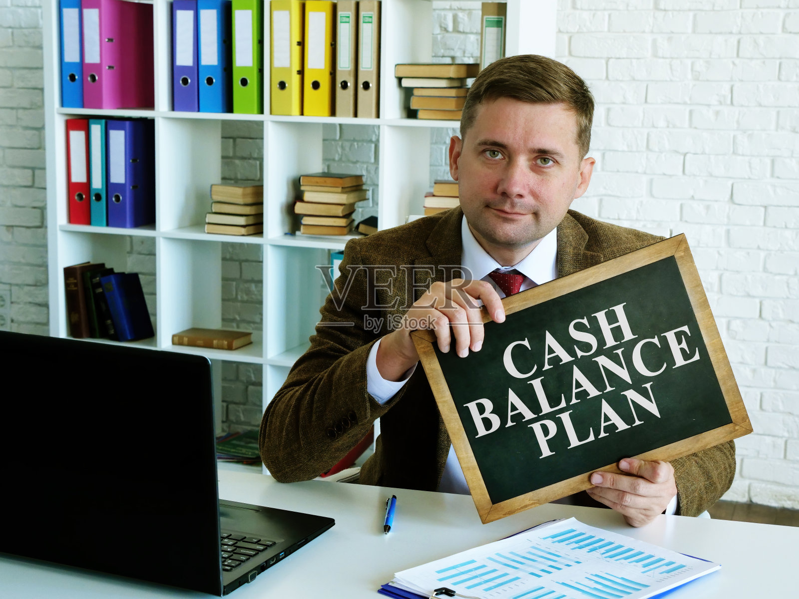 现金余额计划。一名男子举着写有铭文的牌子。照片摄影图片