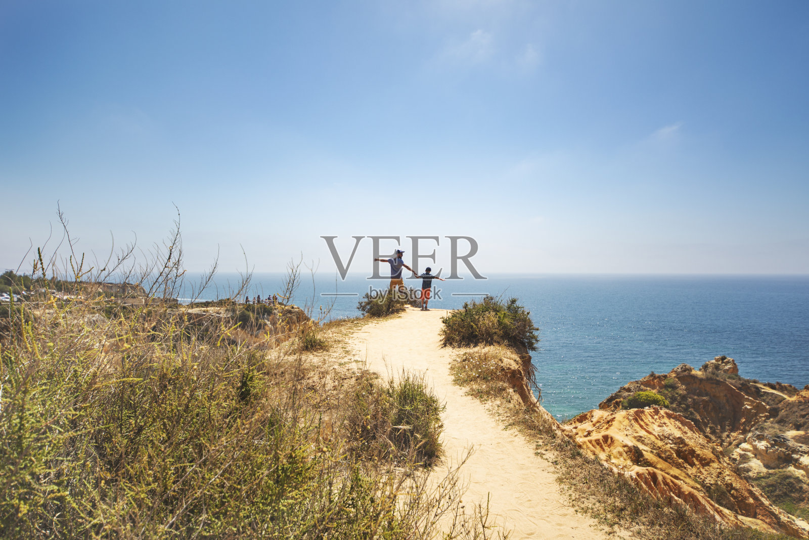 父亲和儿子在海滩上散步照片摄影图片