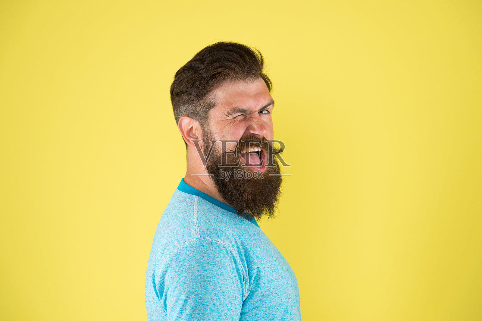 开朗的笑容。留着胡子的嬉皮士。胡子胡子梳理指南。潮人英俊的胡子家伙黄色背景。理发店的概念。留胡子。长胡子照片摄影图片