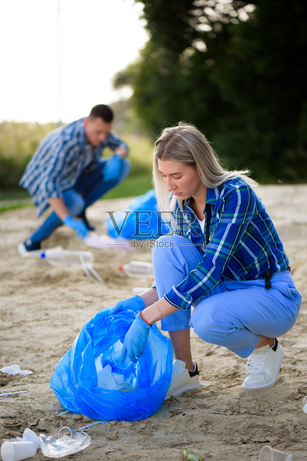 快乐志愿者用垃圾袋清扫公园区域照片摄影图片