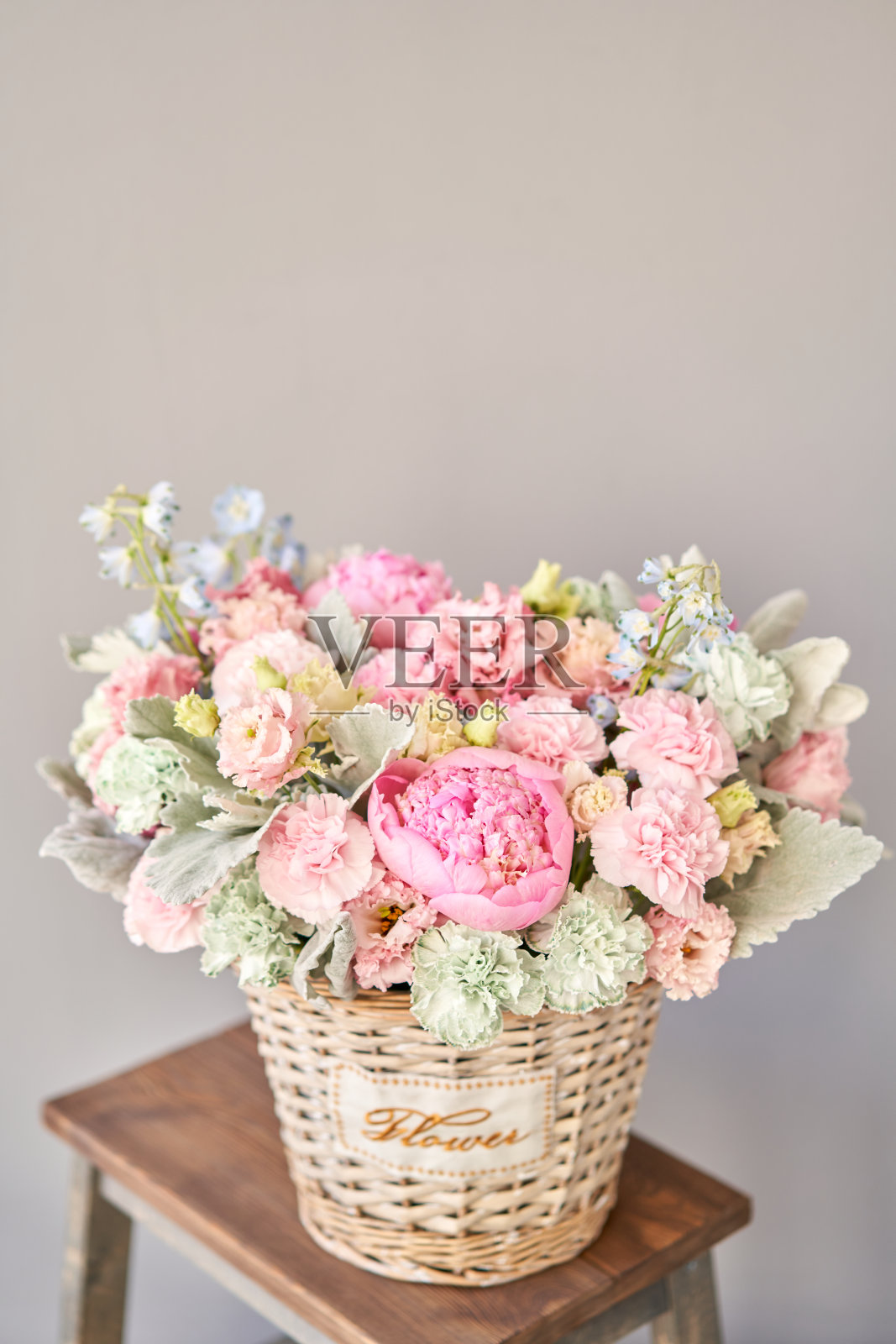 美丽的花组成一束在柳条篮子。花卉栽培技术的概念。春天的颜色照片摄影图片