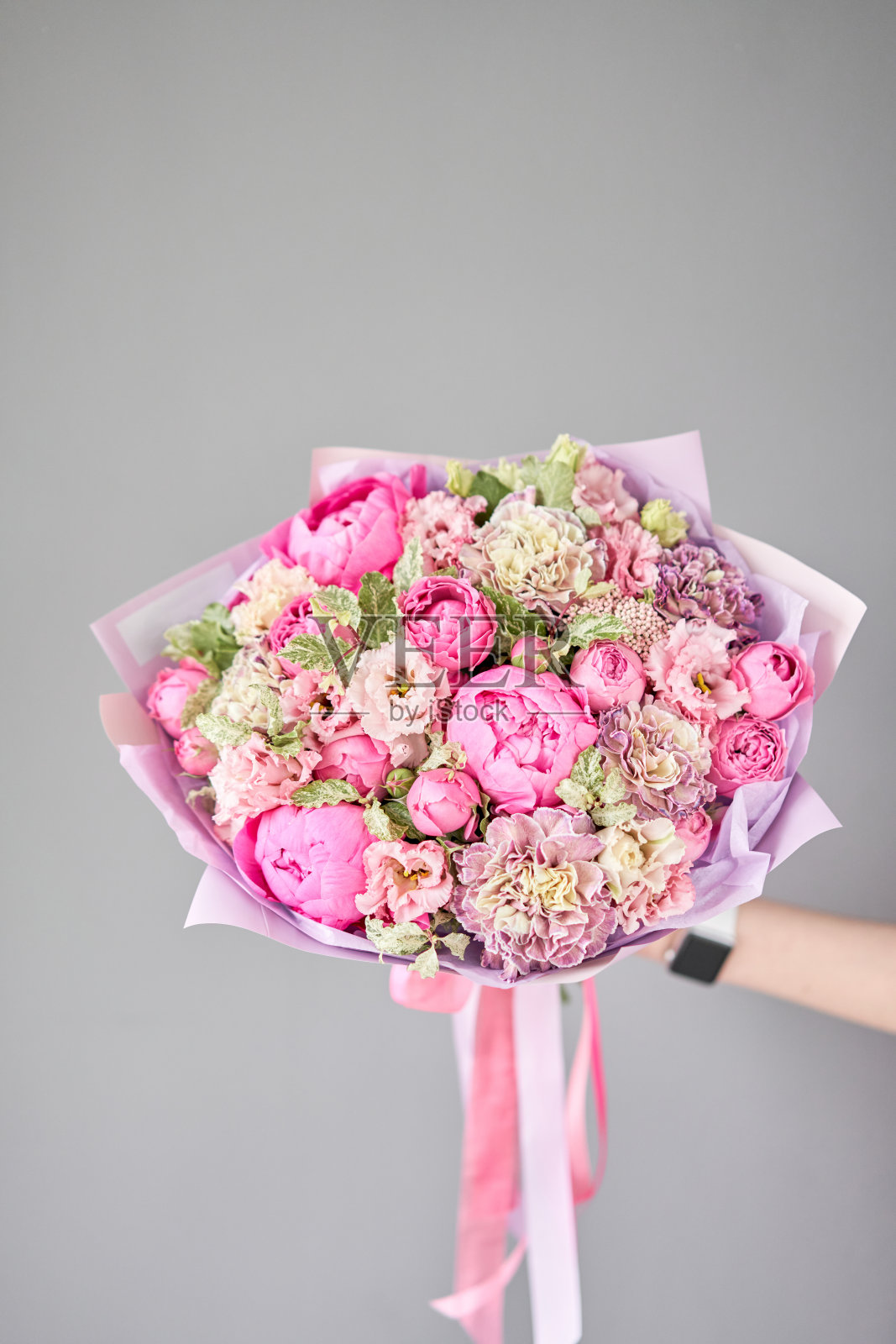 女人手里拿着一束美丽的混合鲜花。花店概念。英俊的新鲜的花束。花交付。照片摄影图片