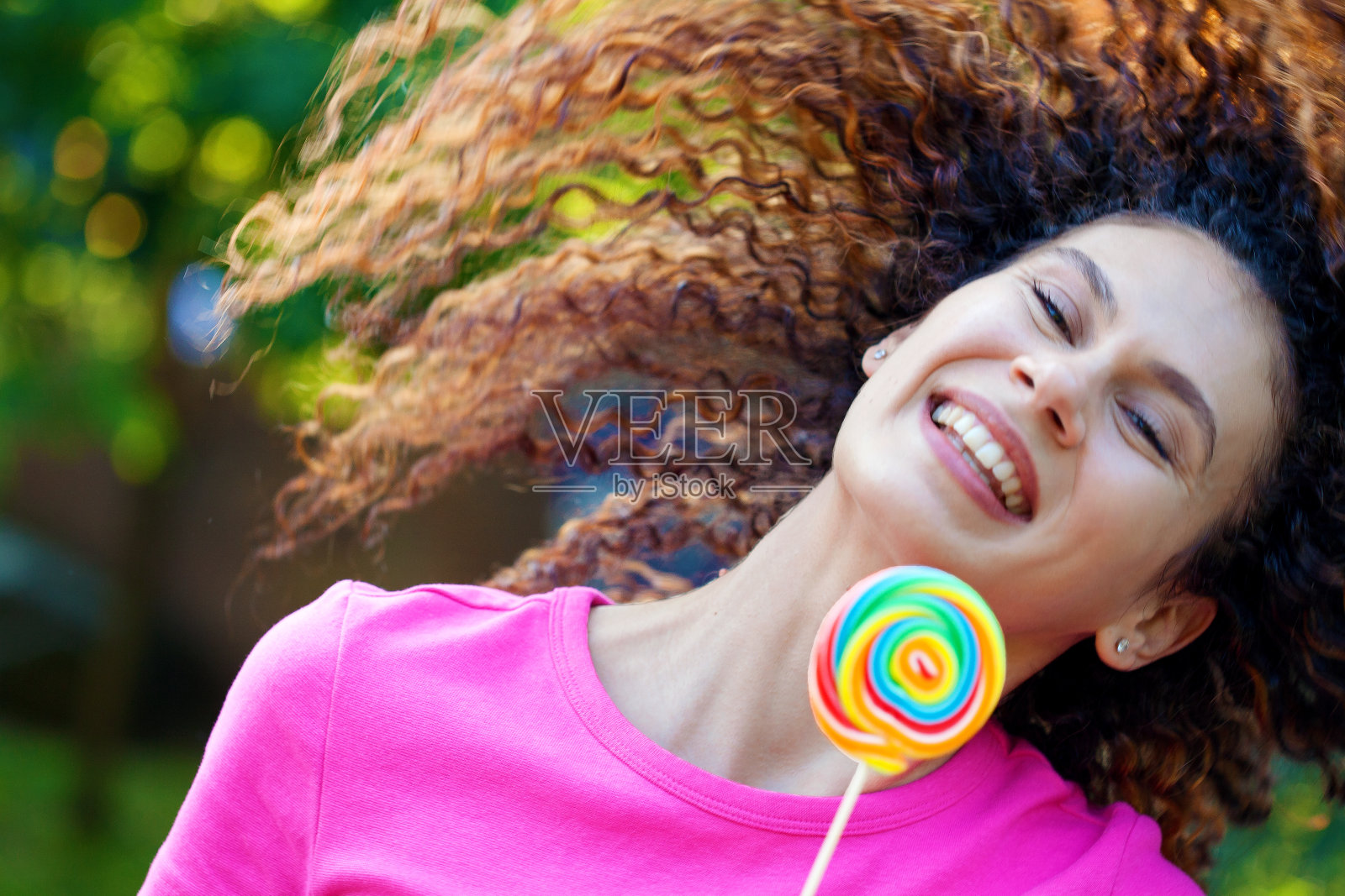 一个拿着棒棒糖的快乐年轻女人的肖像照片摄影图片