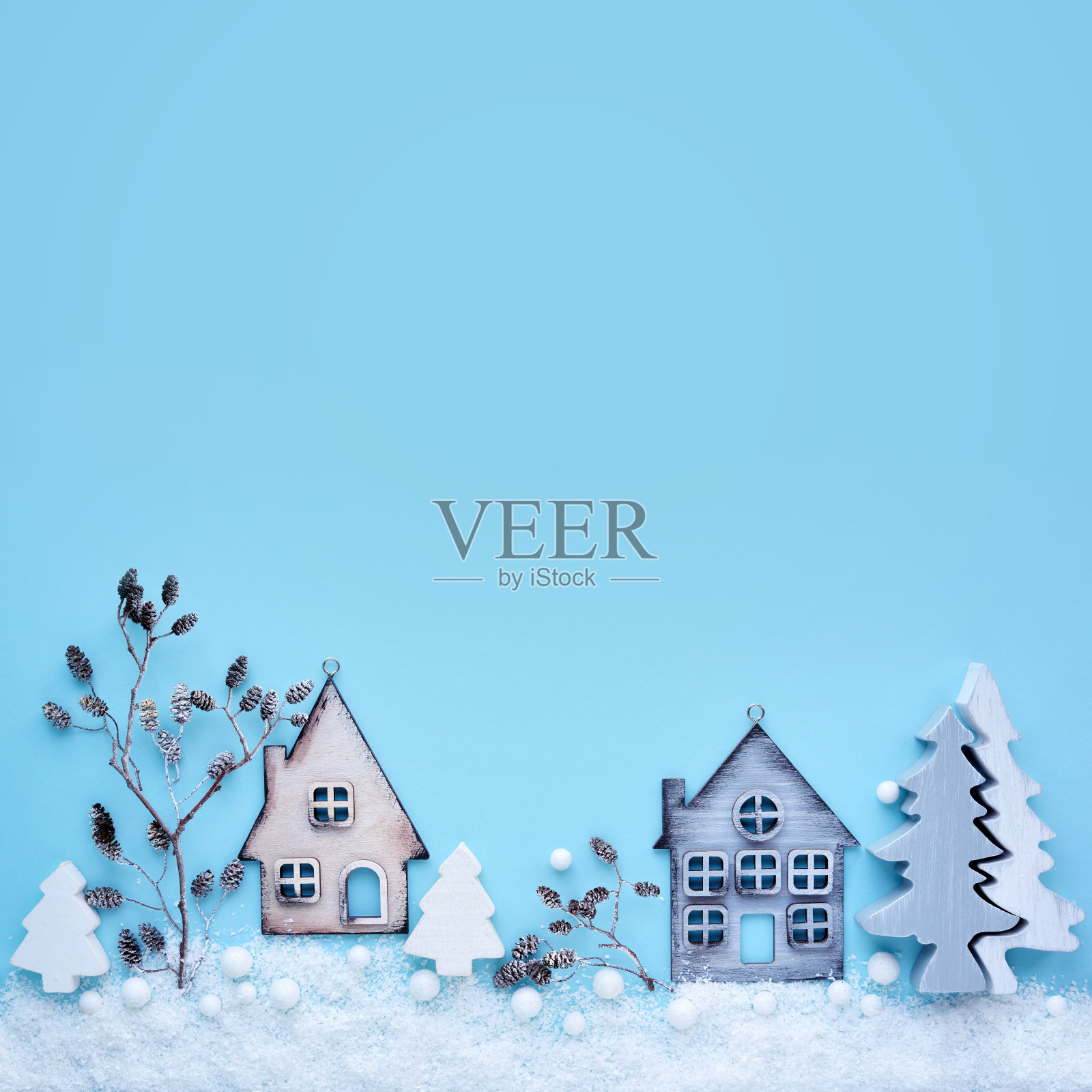 圣诞作文用玩具房子，树枝和树与雪在一个蓝色的背景。新年的背景。美丽的贺卡。副本的空间。俯视图照片摄影图片