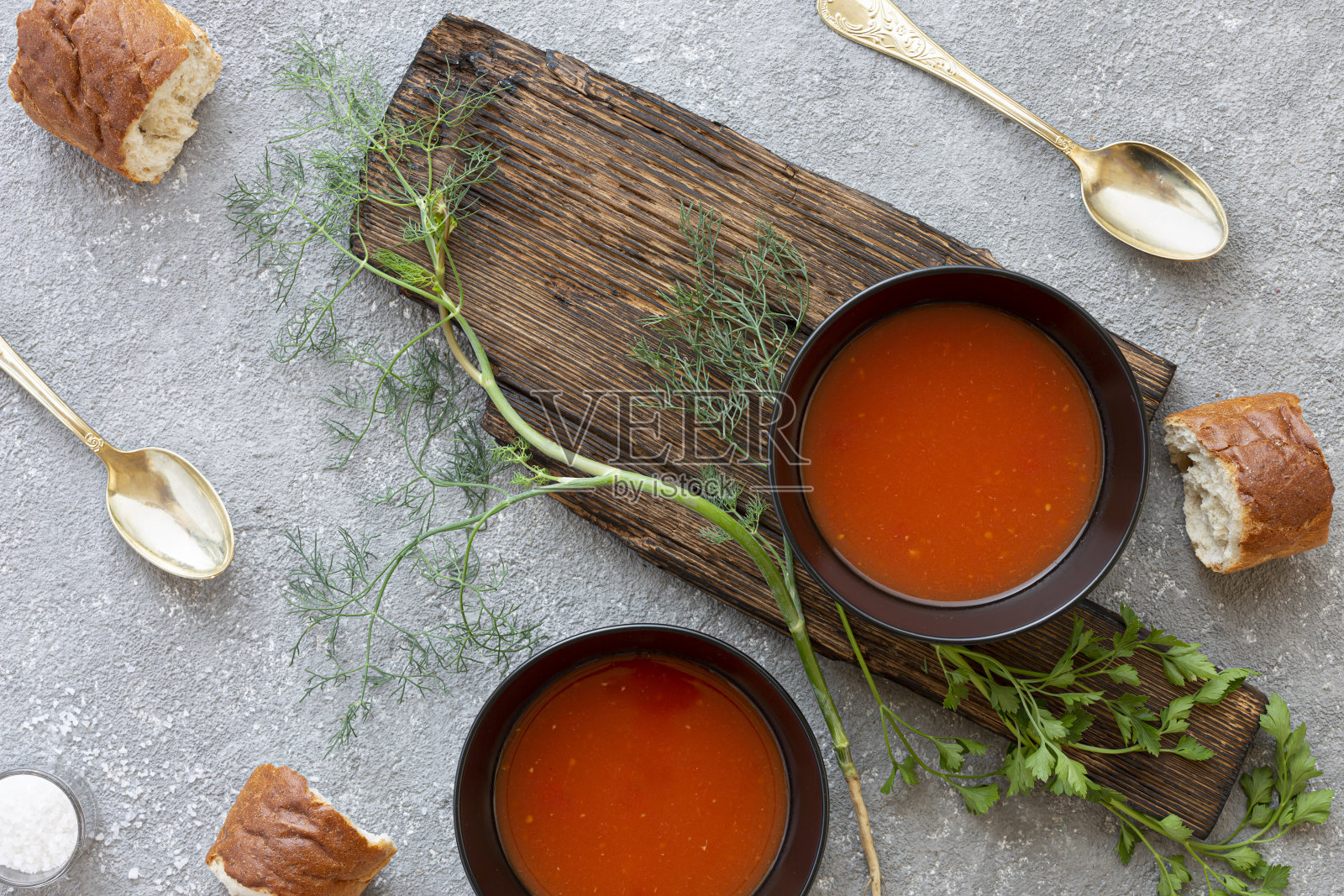 黑色碗中的番茄汤，灰色石头背景。前视图。副本的空间。照片摄影图片
