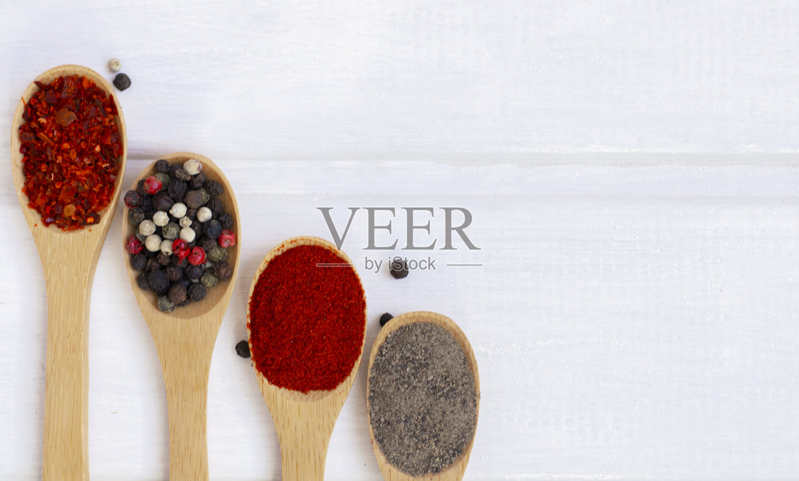 香料混合在一个木勺在白色木制背景。Flatlay。照片摄影图片