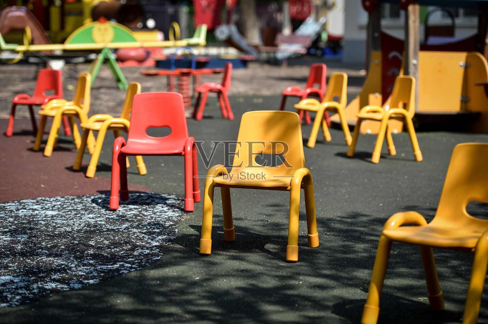在COVID - 19大流行期间，儿童花园游戏区内的空椅子保持社交距离照片摄影图片