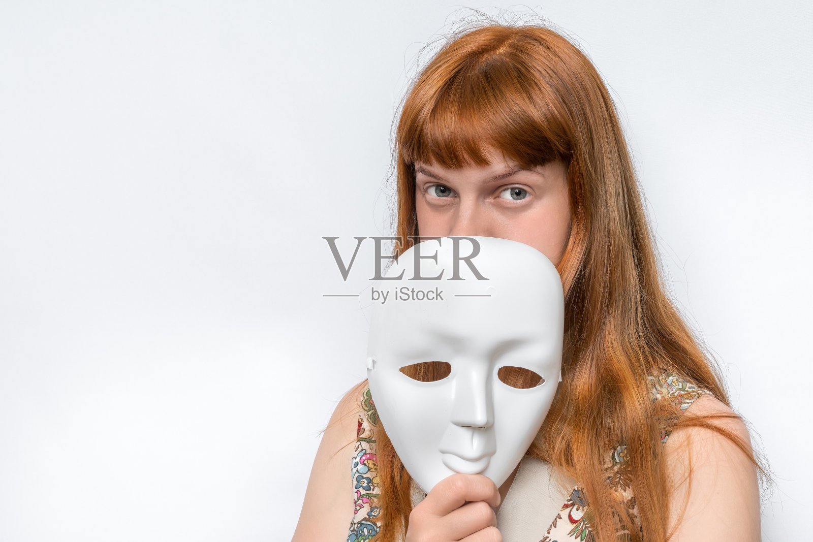 神秘的女人用面具遮住了自己的脸照片摄影图片