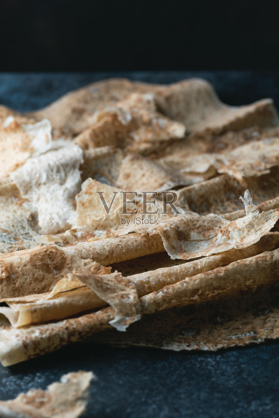 自制的亚美尼亚薄皮塔饼铺在深蓝色的石头上。有选择性的重点。照片摄影图片