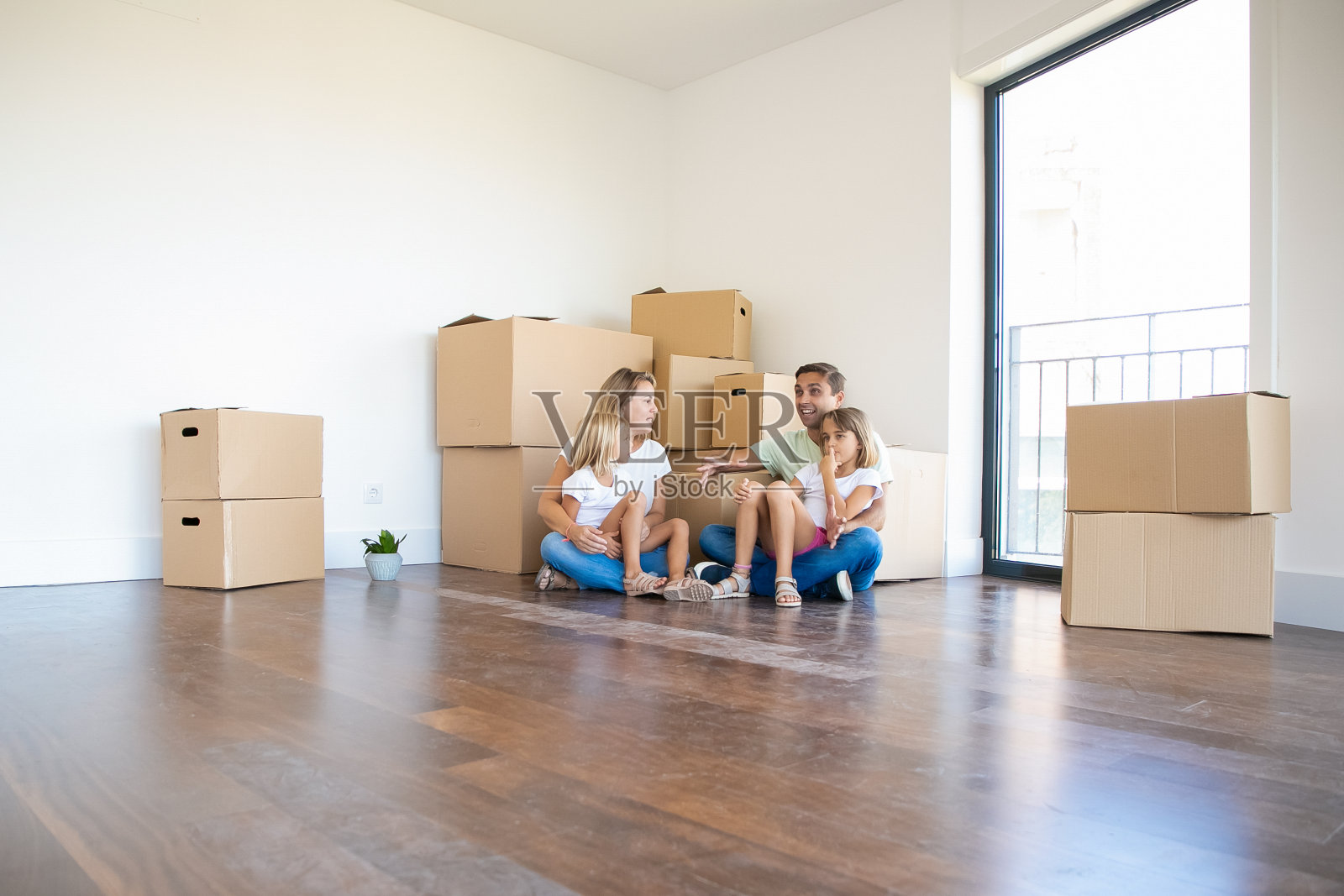 快乐的年轻家庭在地板上放松在搬迁期间照片摄影图片